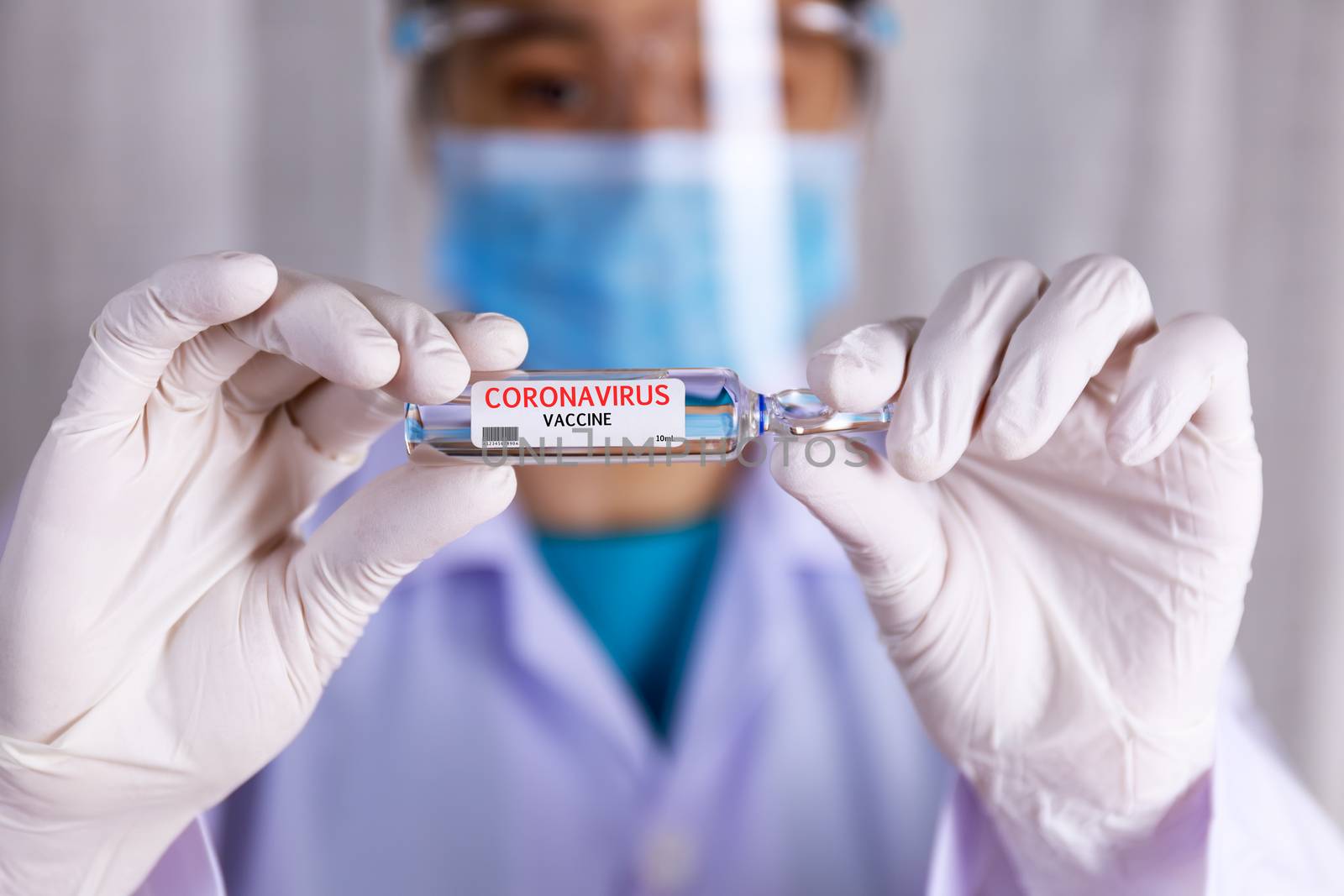 Covid-19, coronavirus vaccine. Close up hands of scientist show Covid-19 vaccine in glass vial. Hands of doctor wear white latex glove holding Covid-19 vaccine in glass vial. Healthcare and medical concept.

