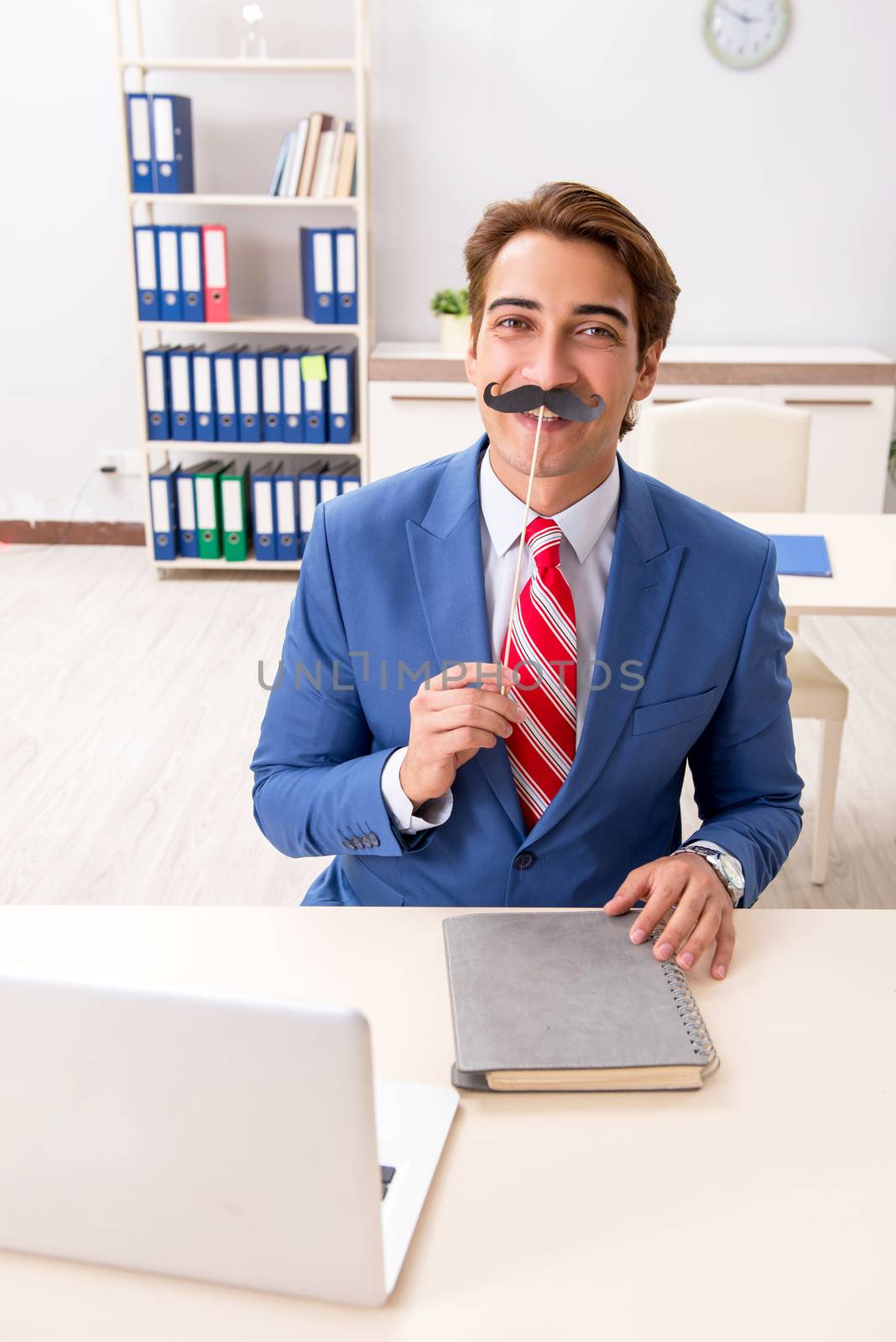 Funny bisinessman with fake moustache in the office