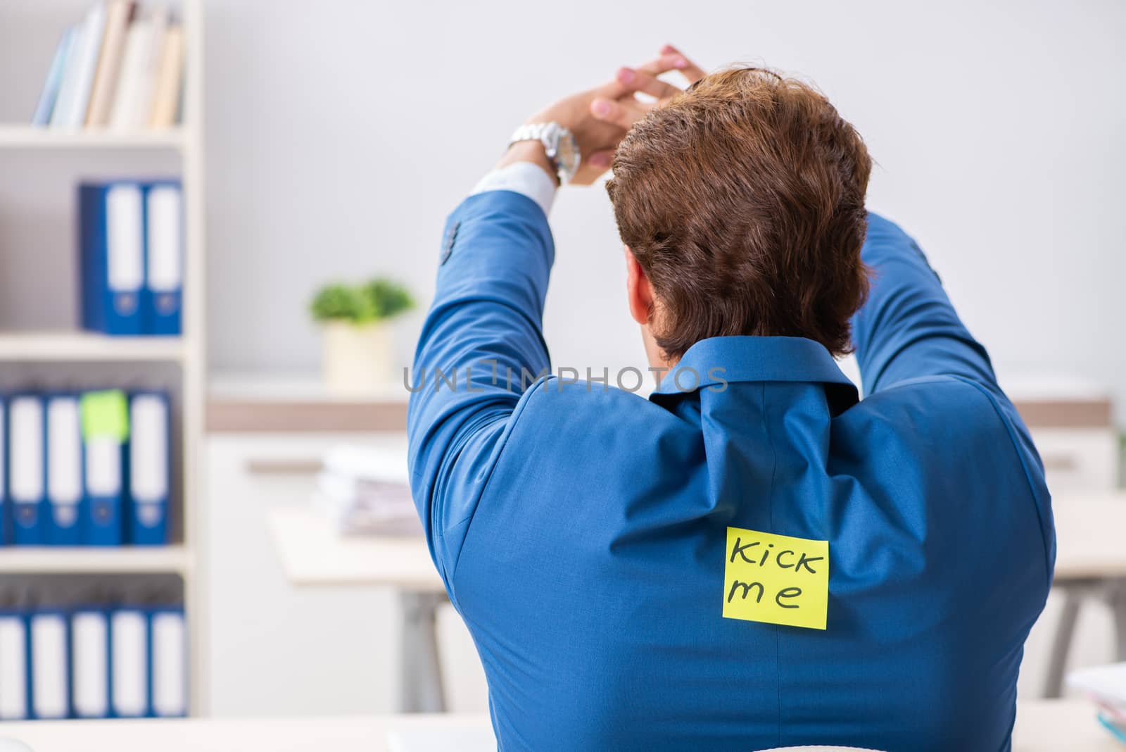 Office prank with kick me message on sticky note