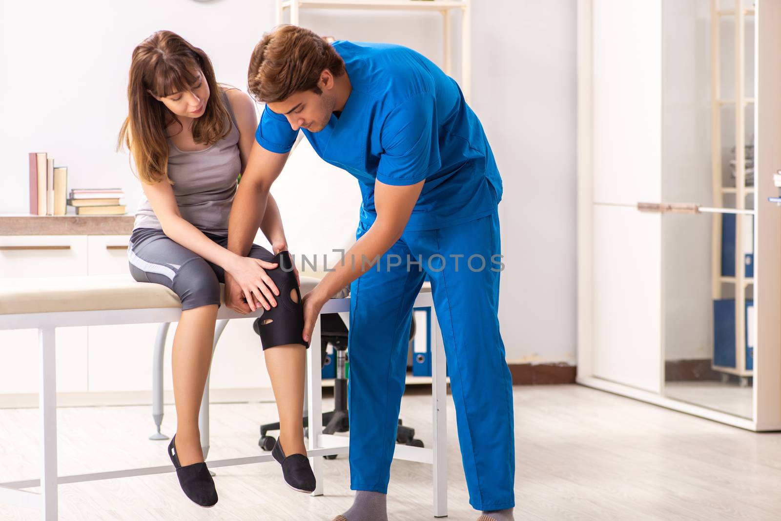 Young female patient visiting male doctor traumatologist 