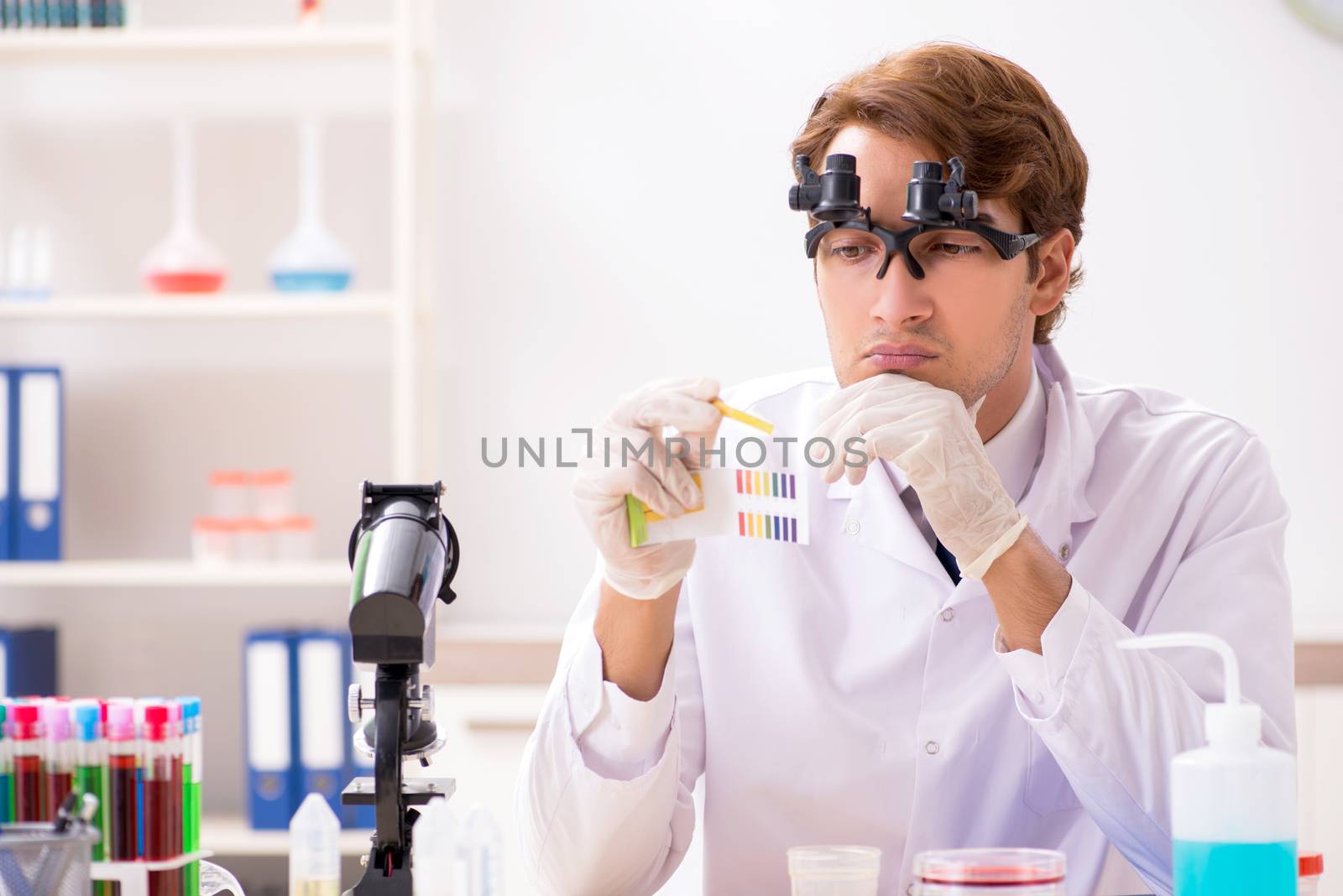Chemist in the lab checking with ph strips