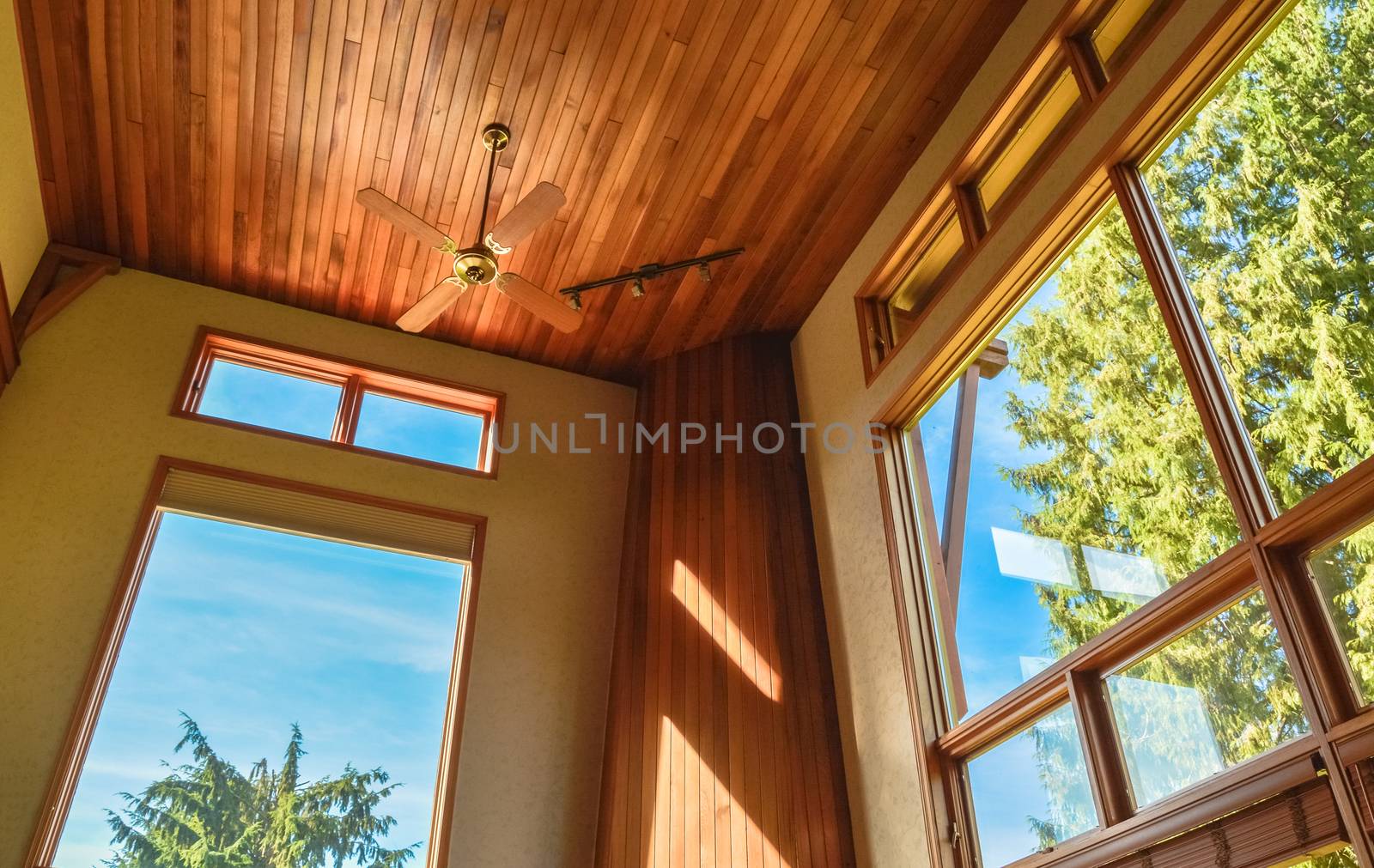 Stained glass windows in spacious living room with high ceiling decorated in wood