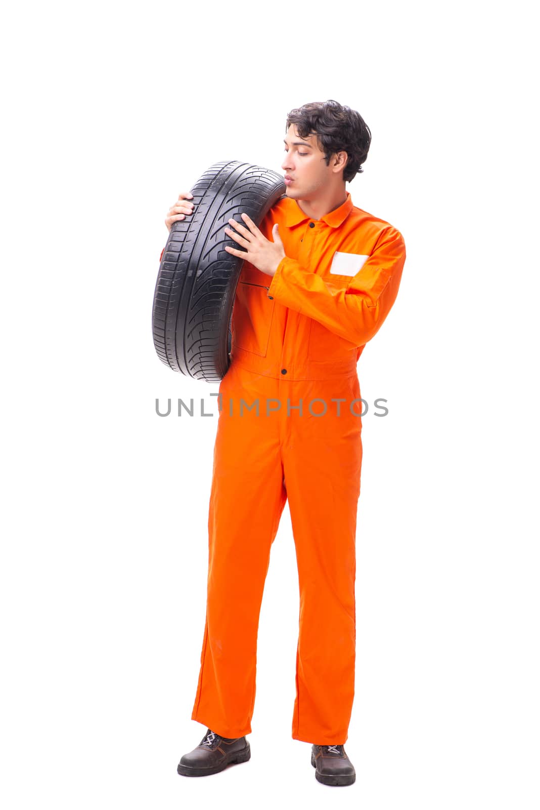 Young garage worker with tyre isolated on white