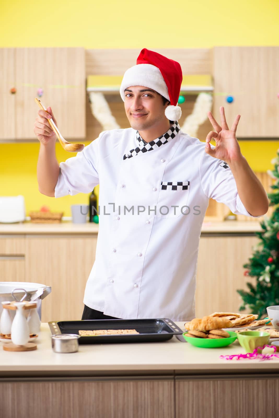 Young chef husband working in kitchen at Christmas eve 