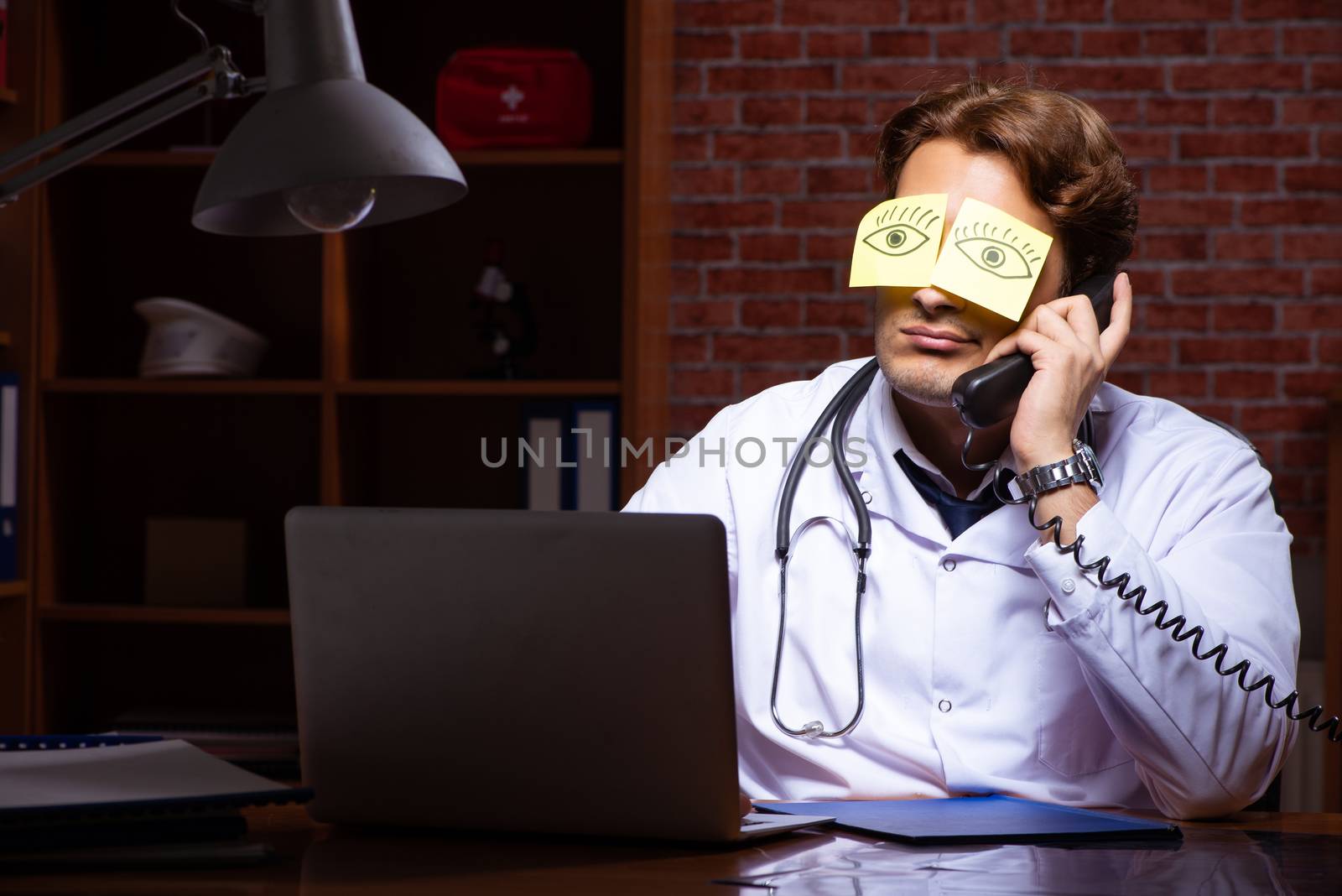 Young handsome doctor working night time at the hospital 