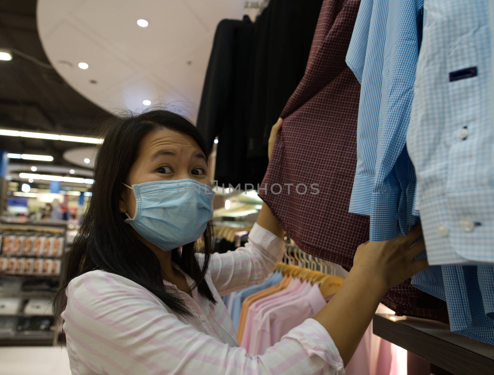 A woman shopping in a mall wearing a protective mask to prevent the coronavirus.