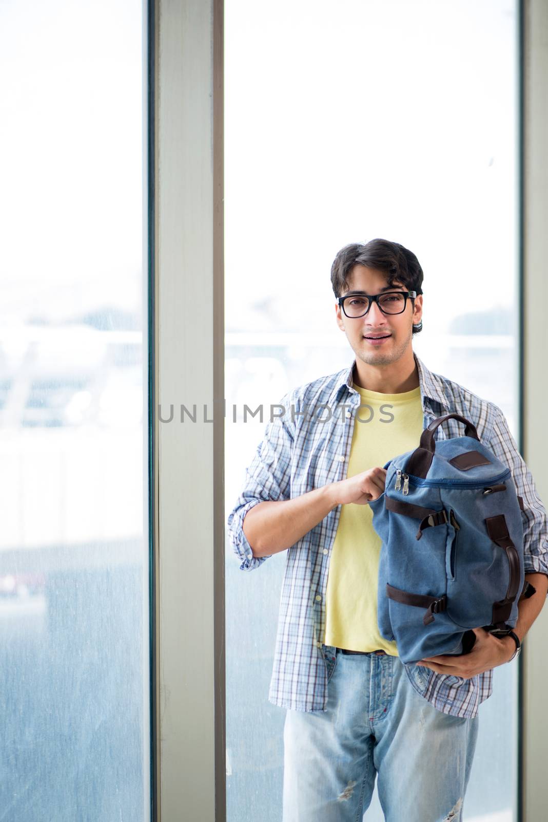 Young handsome student standing at the window 