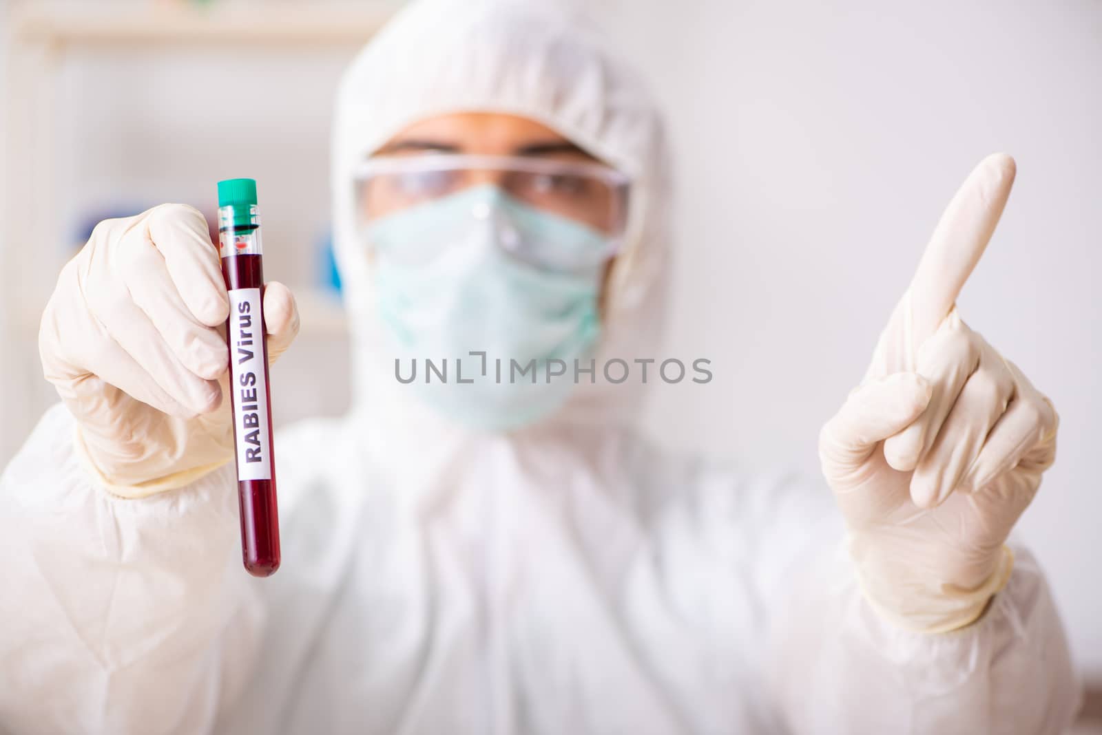 Young handsome lab assistant testing blood samples in hospital 