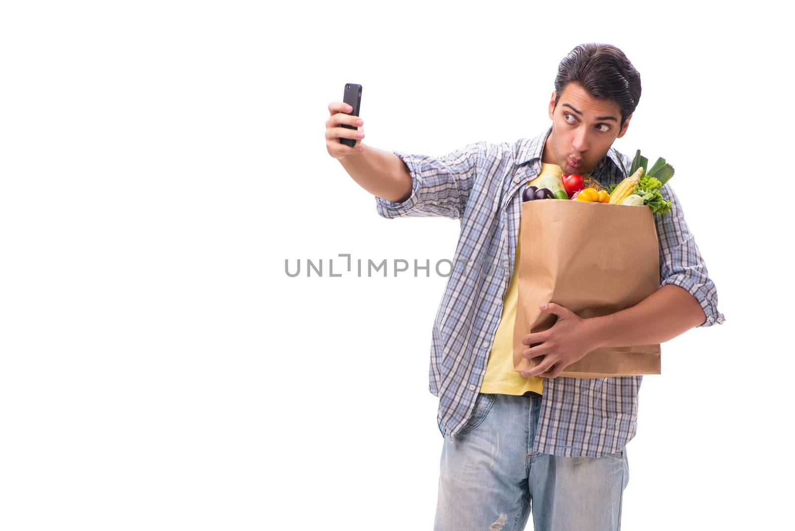 Young man with his grocery shopping on white
