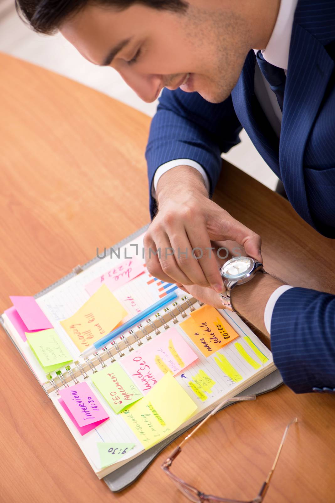 Young handsome employee planning his work activity 
