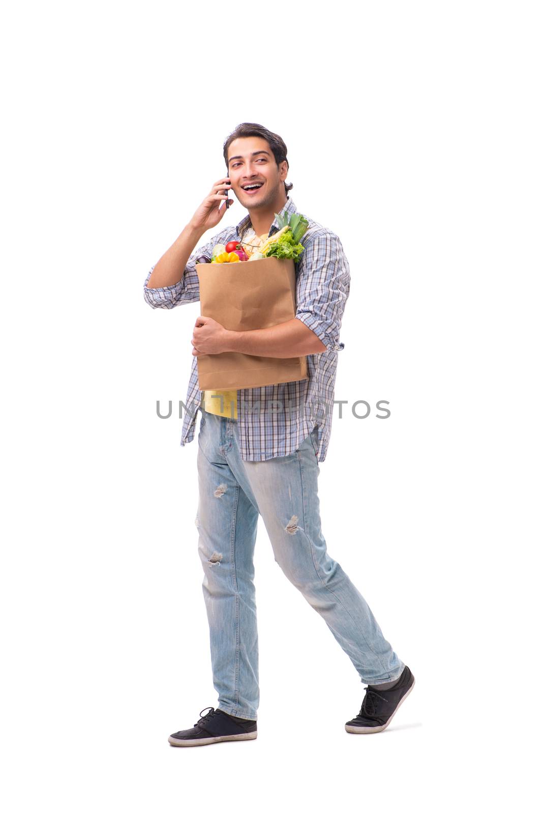 Young man with his grocery shopping on white
