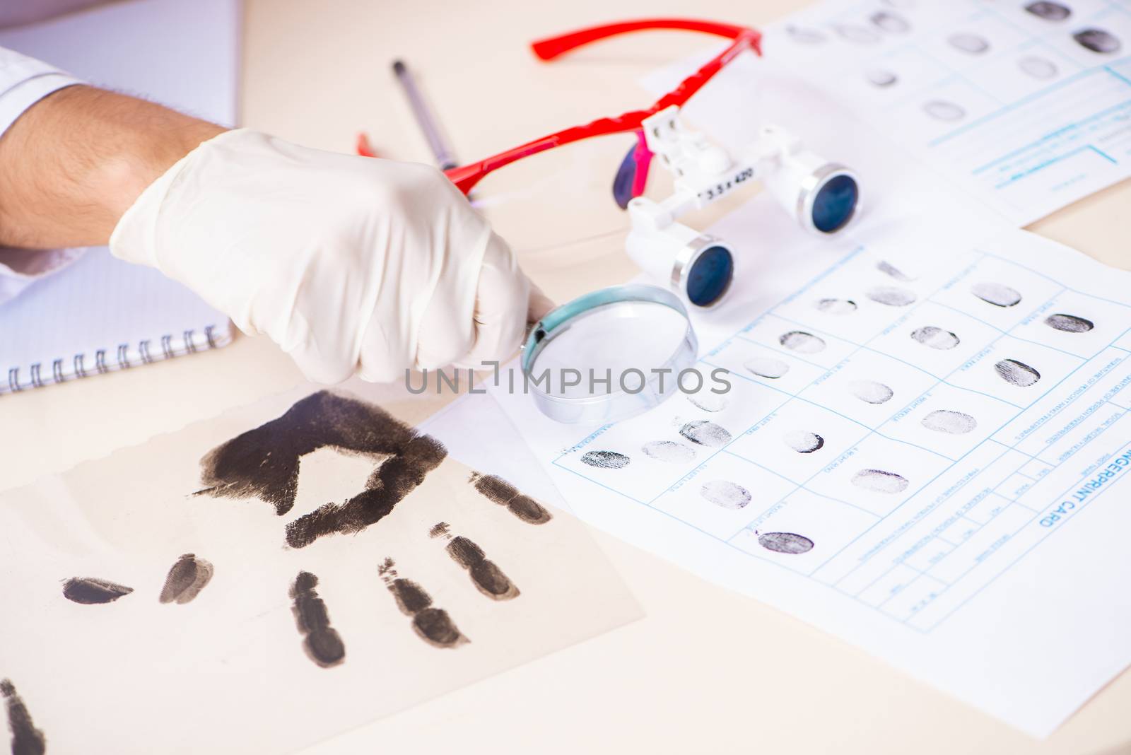 Forensic expert studying fingerprints in the lab by Elnur