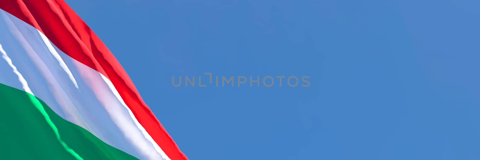 3D rendering of the national flag of Hungary waving in the wind against a blue sky.