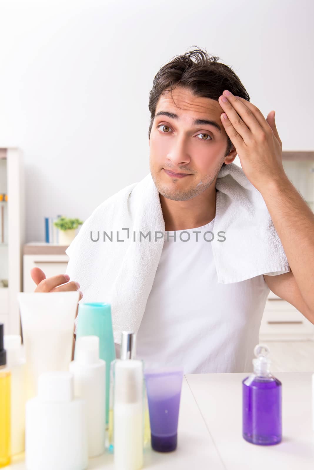 Young handsome man in the bathroom in hygiene concept 