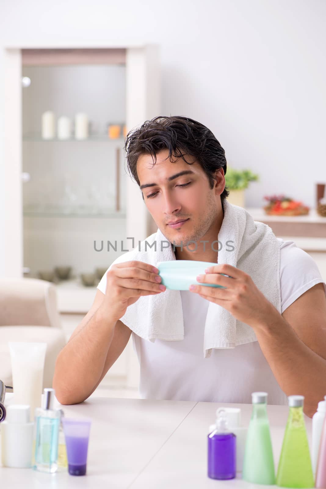 Young handsome man in the bathroom in hygiene concept 