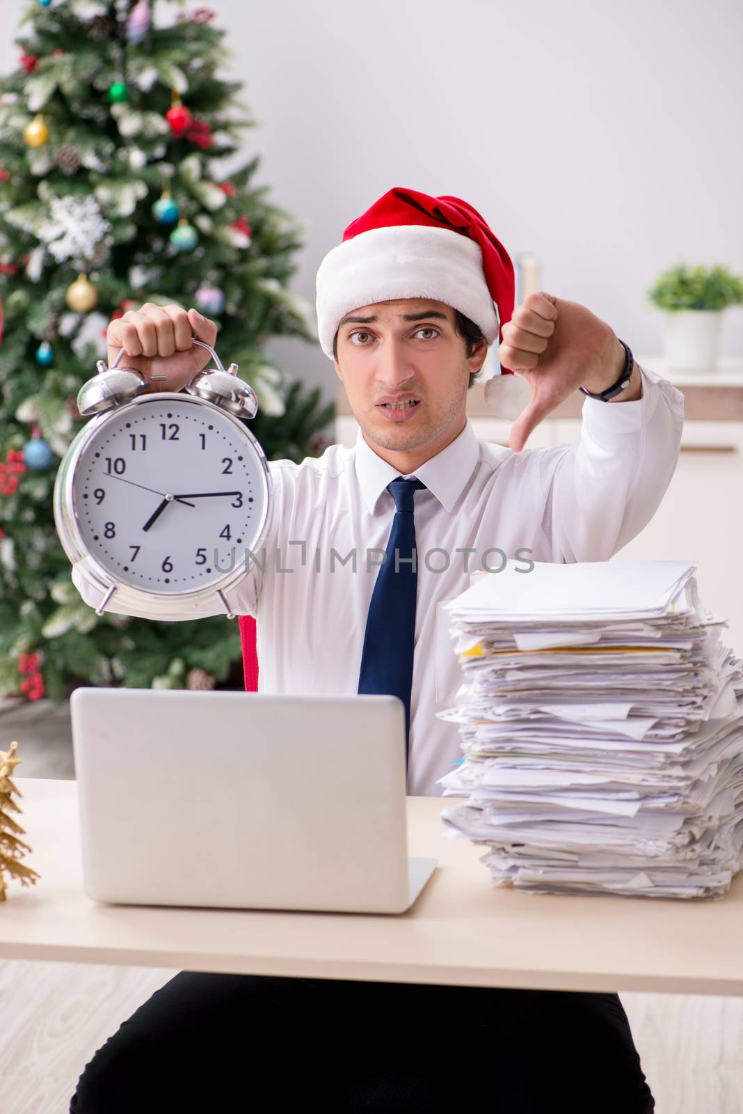 Young worker working in office on christmas shift by Elnur