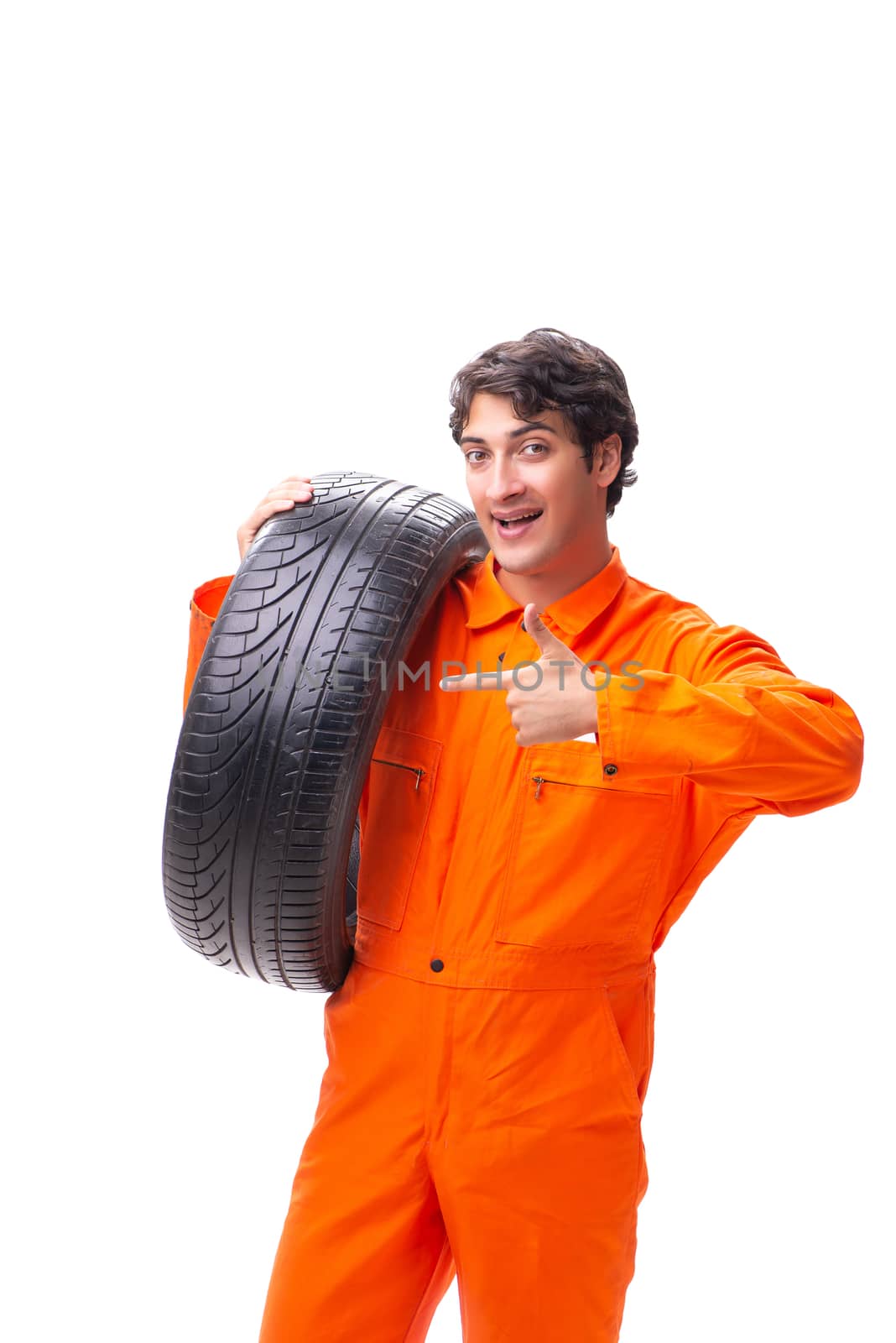 Young garage worker with tyre isolated on white