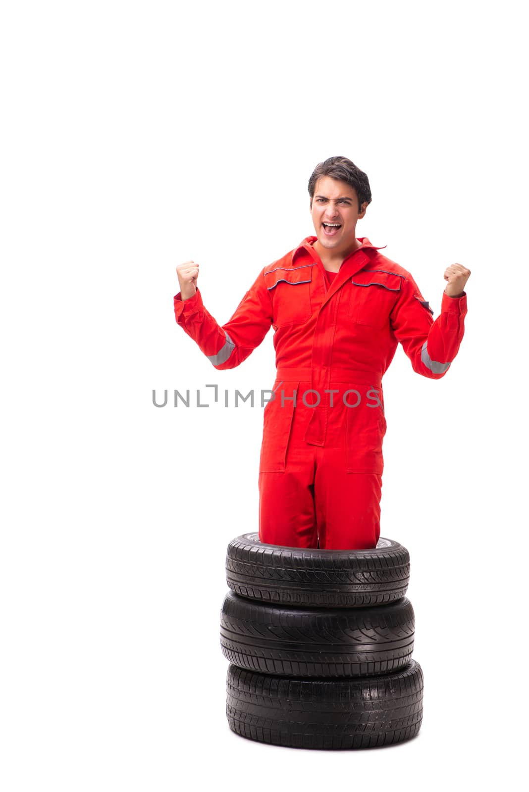 Young garage worker with tyre isolated on white