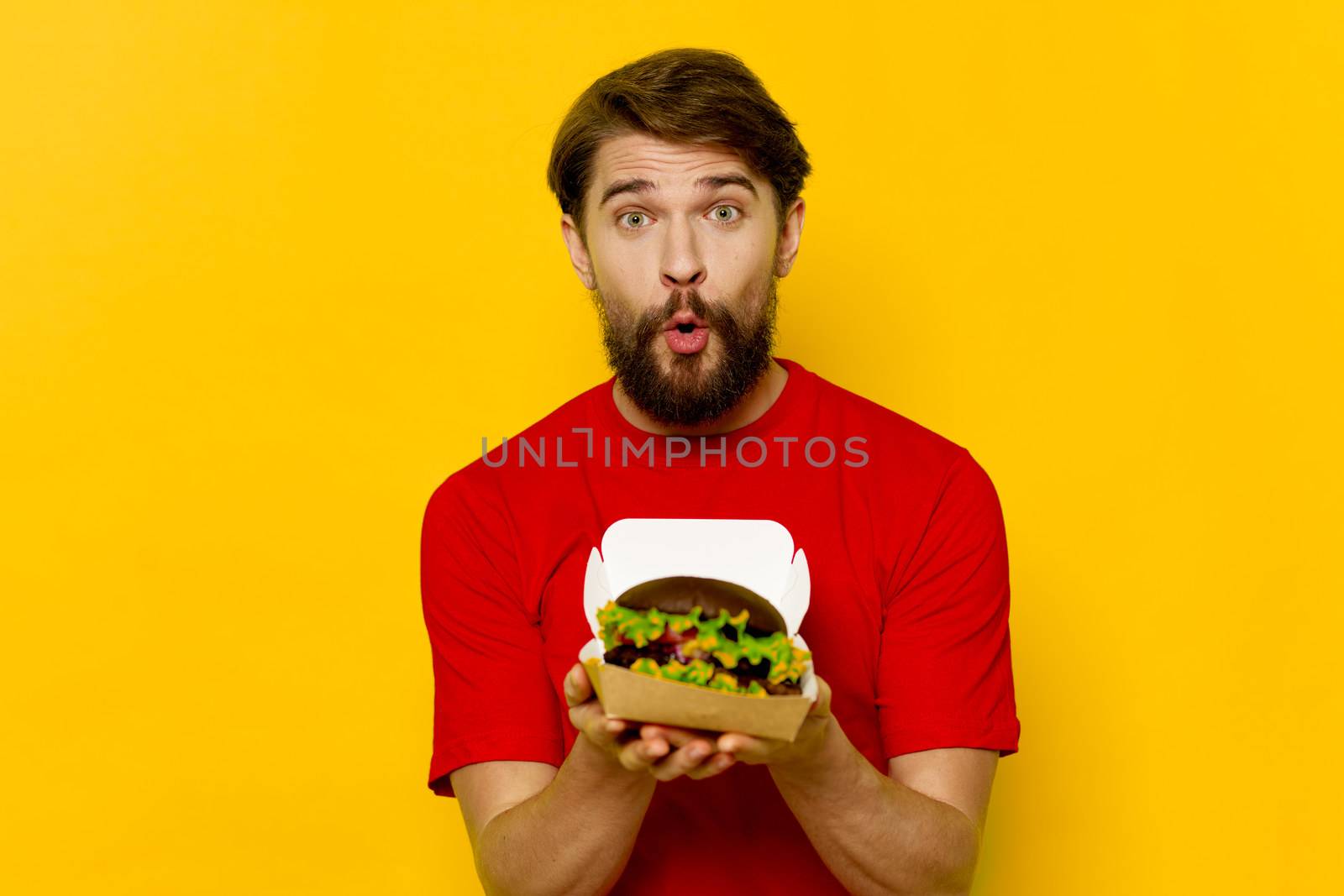 Man with hamburger fast food diet red t-shirt restaurants eating