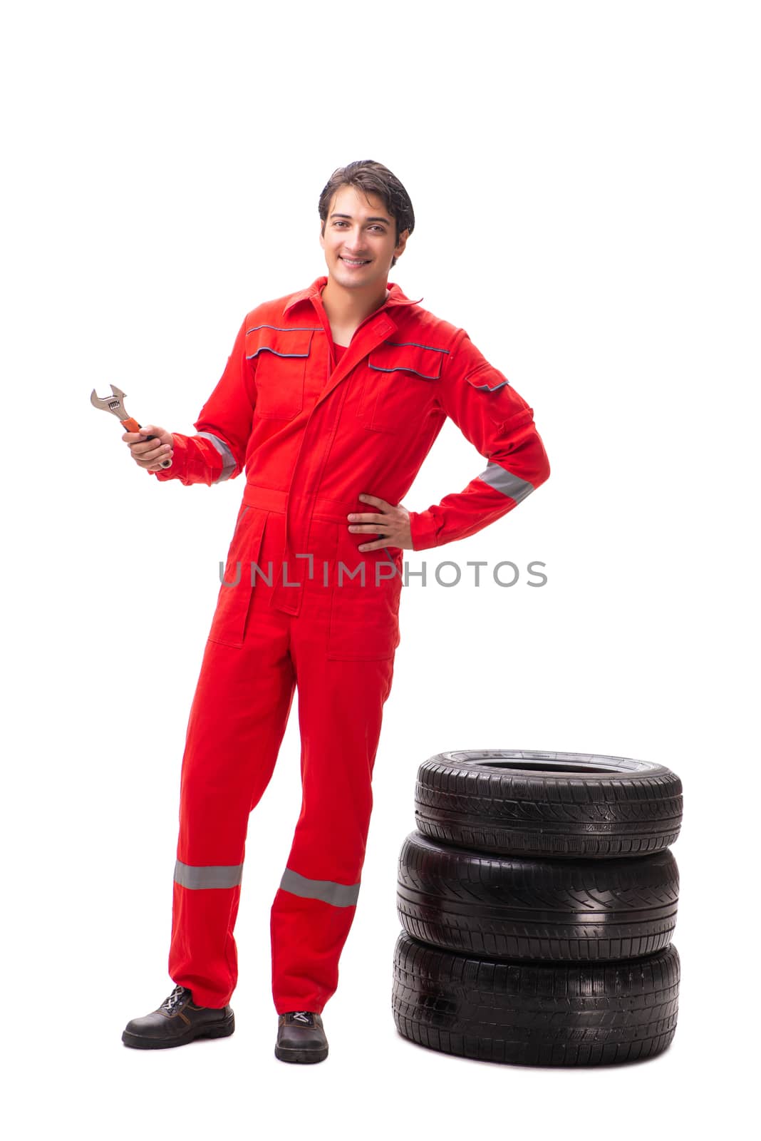 Young garage worker with tyre isolated on white