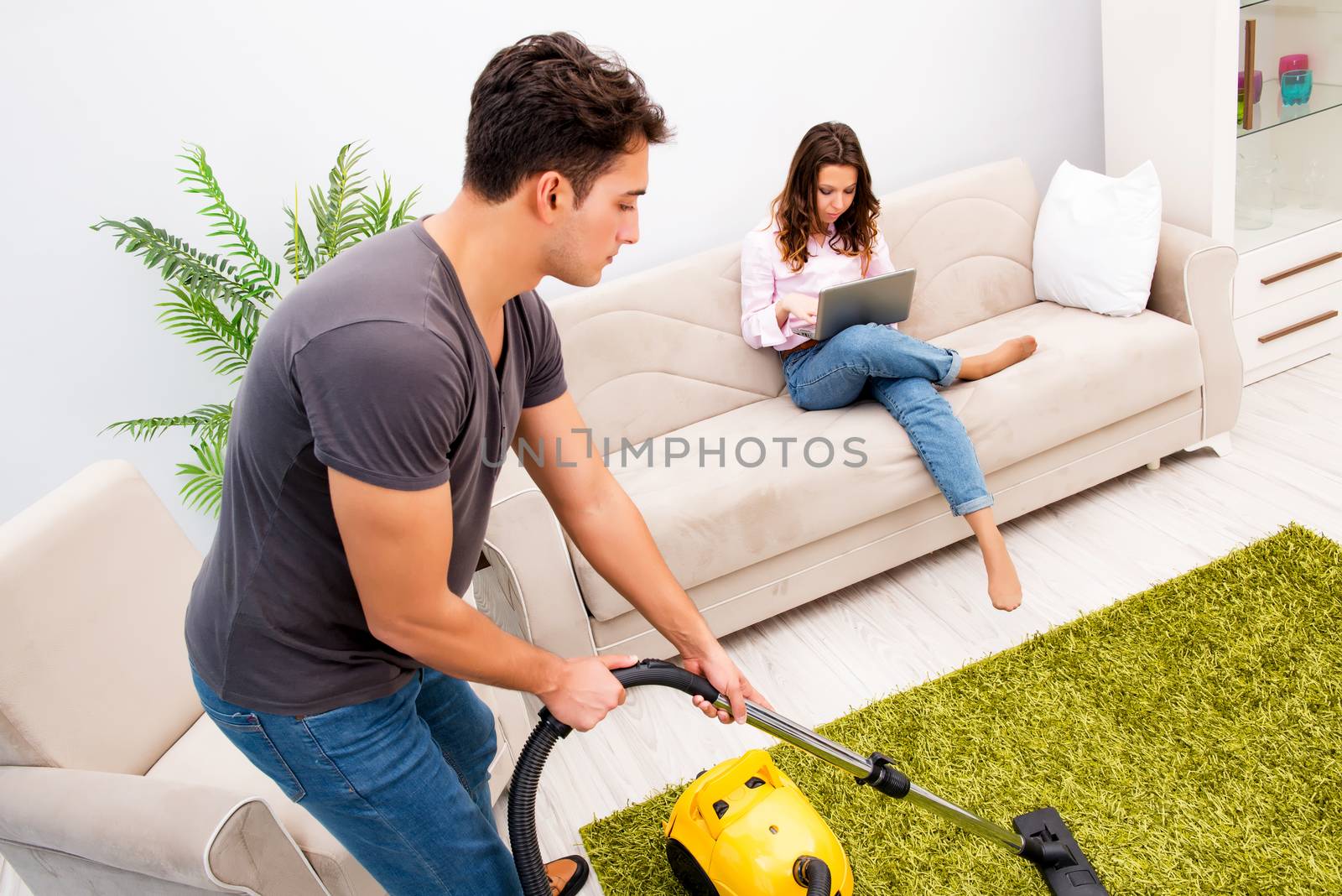 Young family doing cleaning at home by Elnur