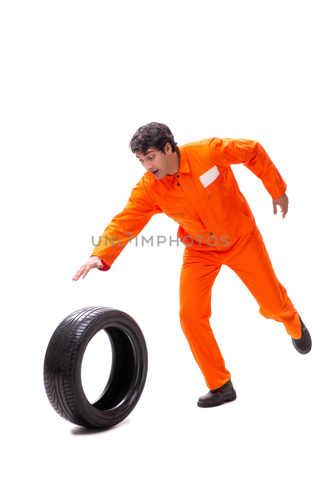 Young garage worker with tyre isolated on white