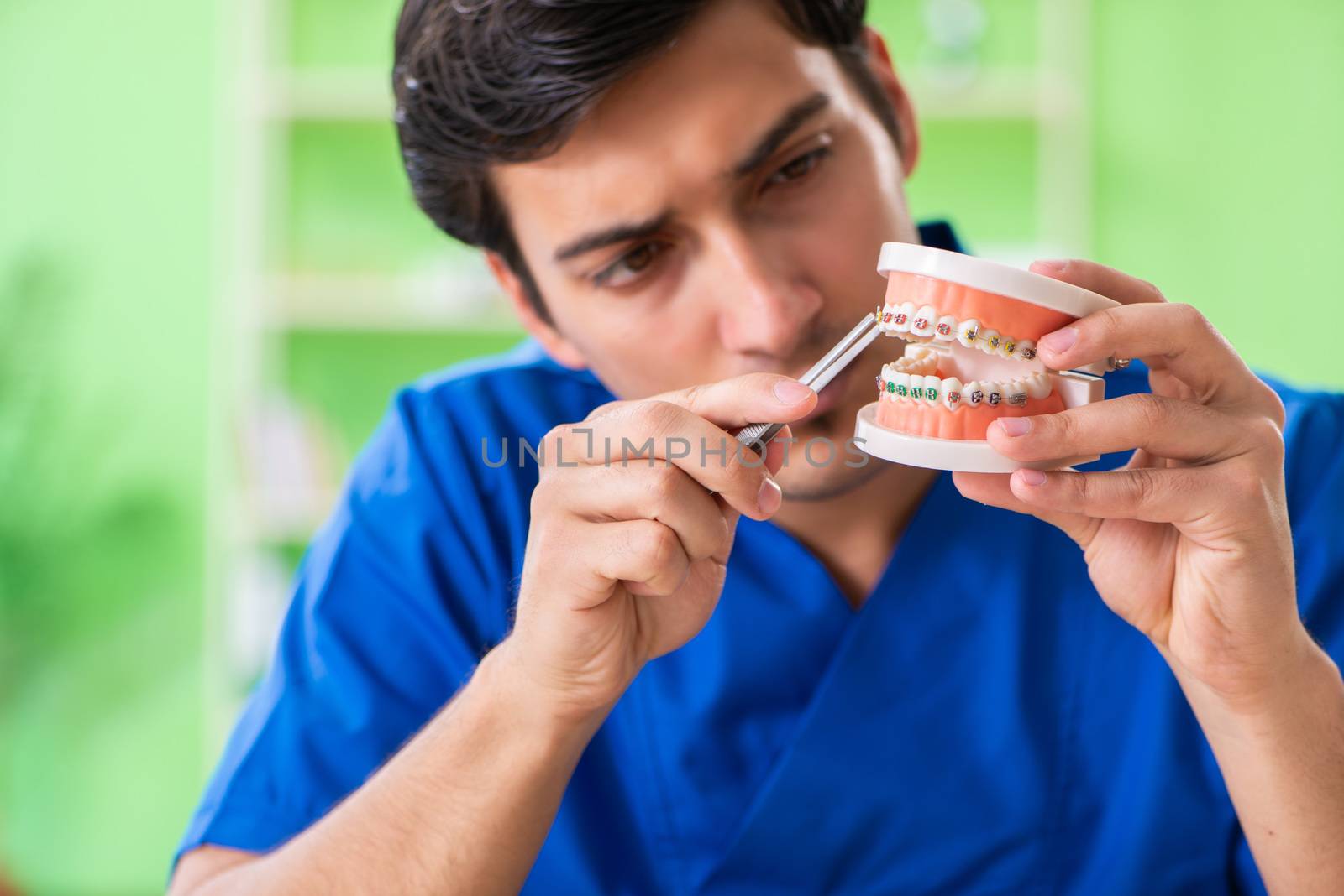 Man dentist working on new teeth implant 
