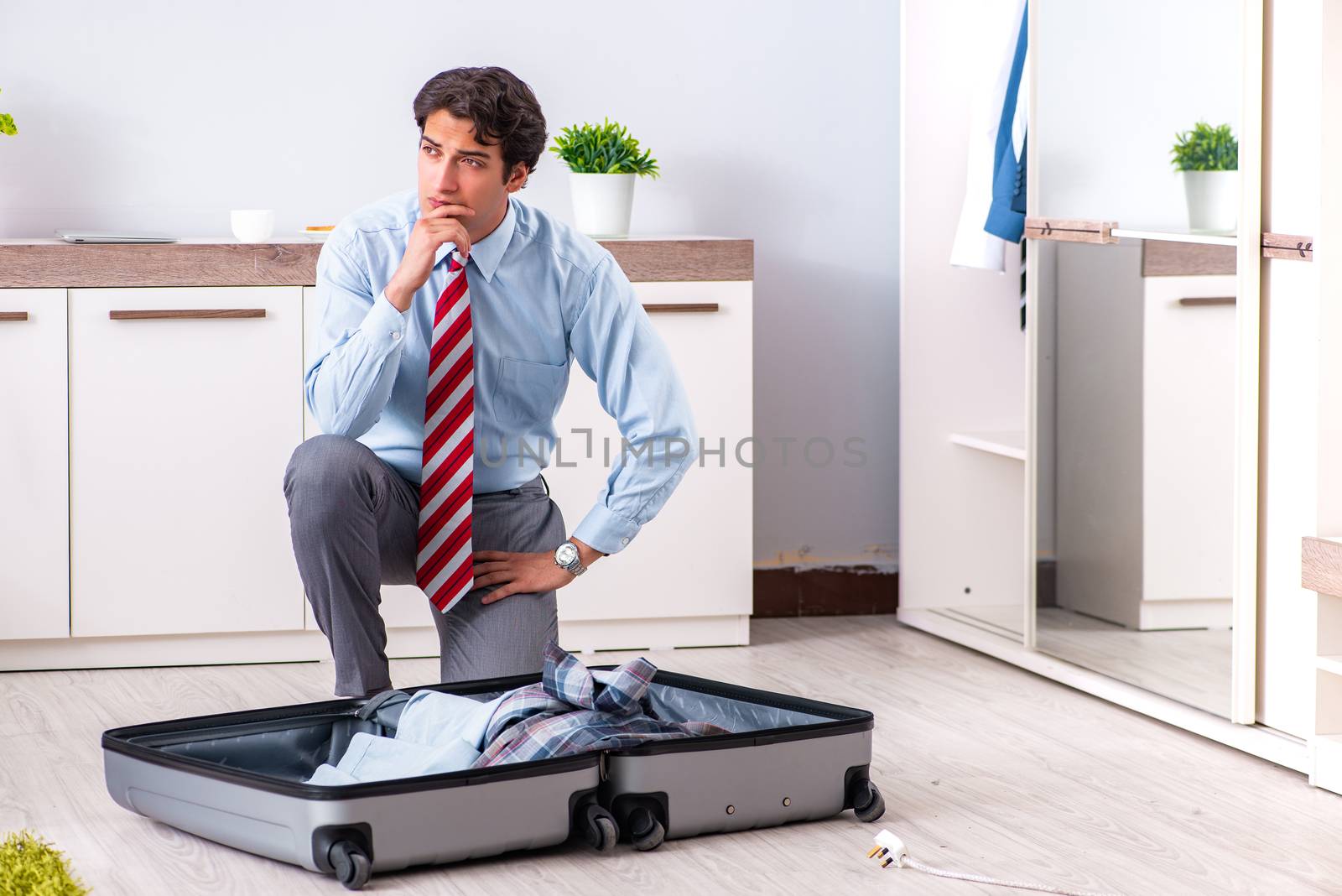 Young handsome businessman preparing for trip