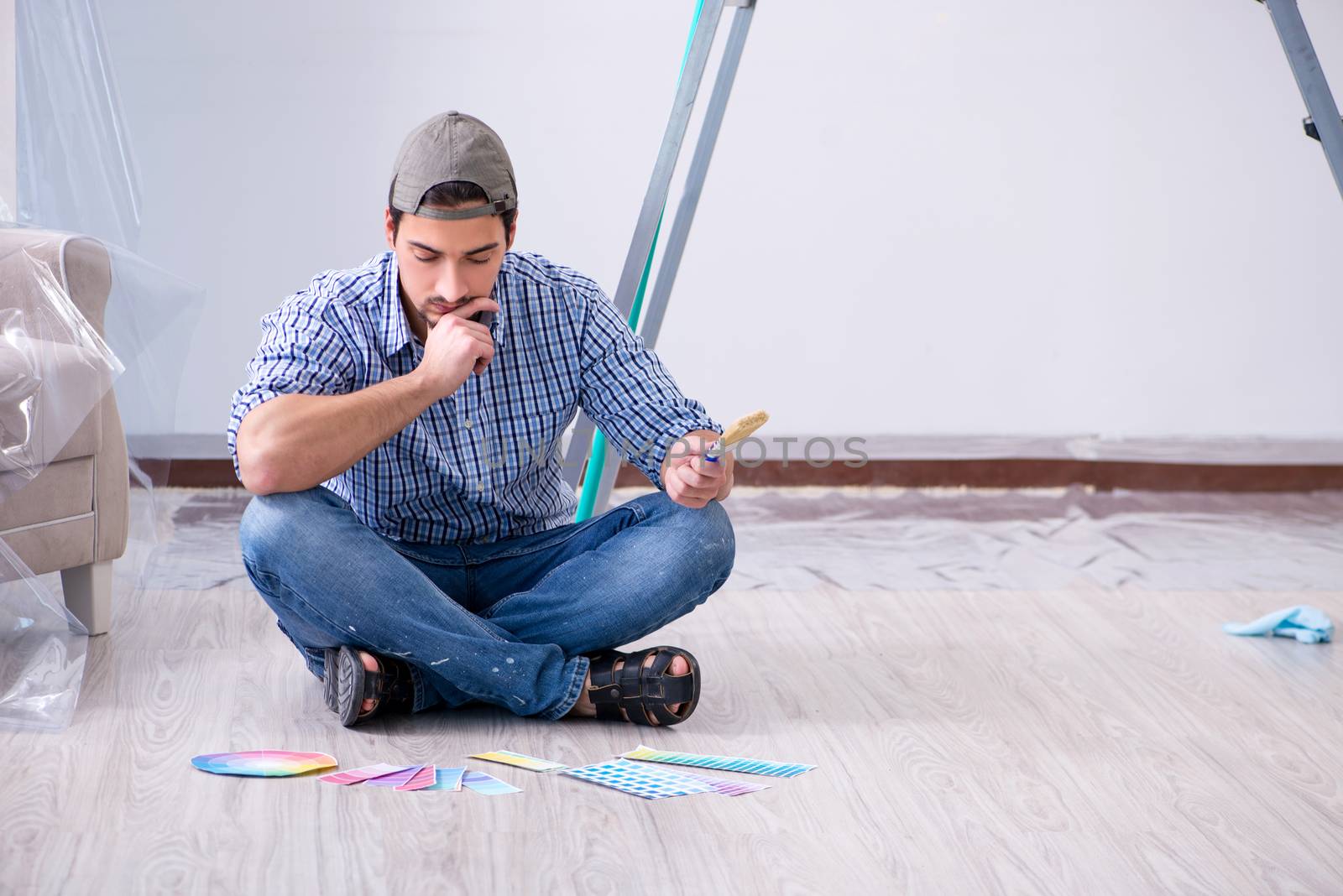 Young man contractor choosing color from rainbow 