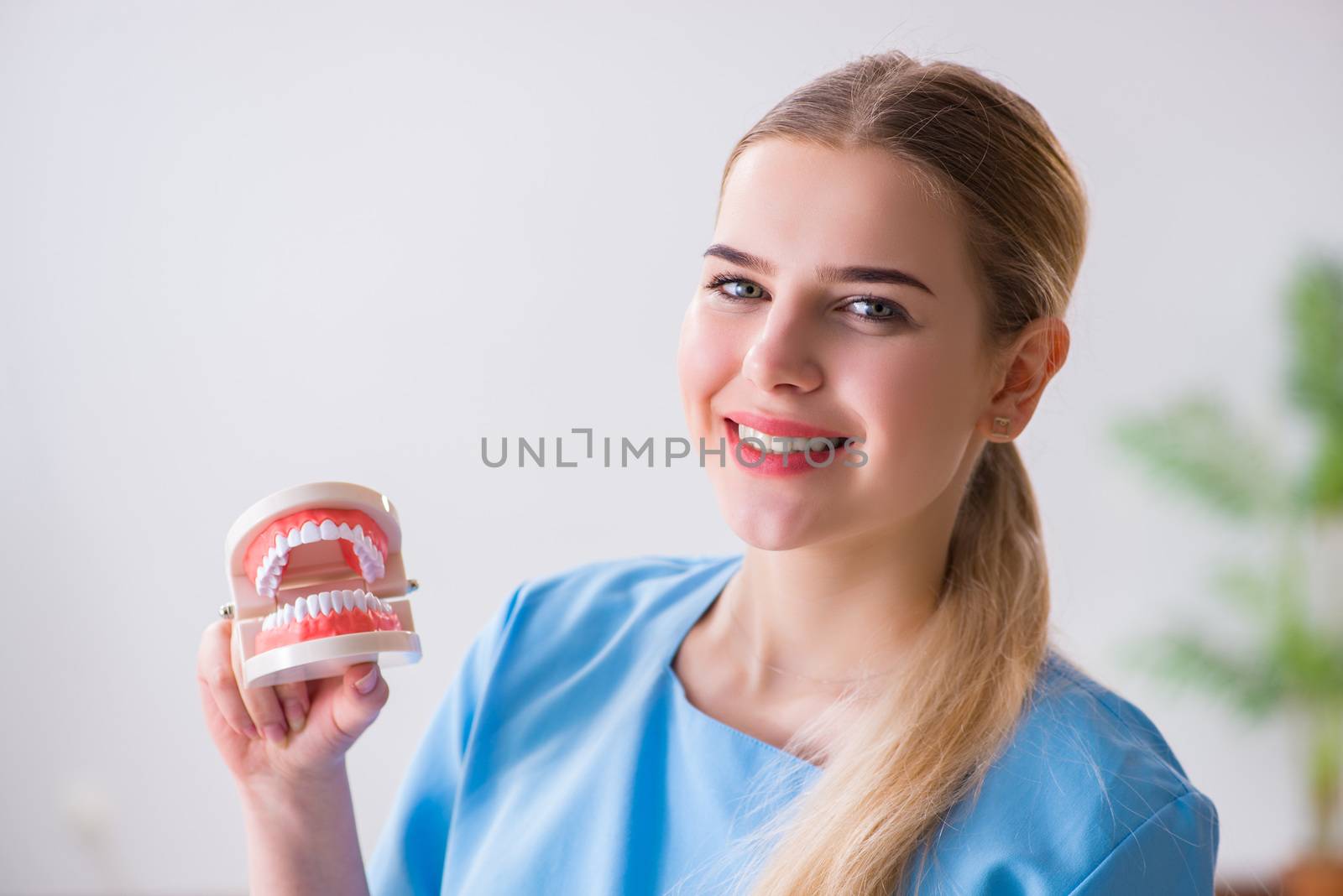 Young doctor nurse with dentures by Elnur