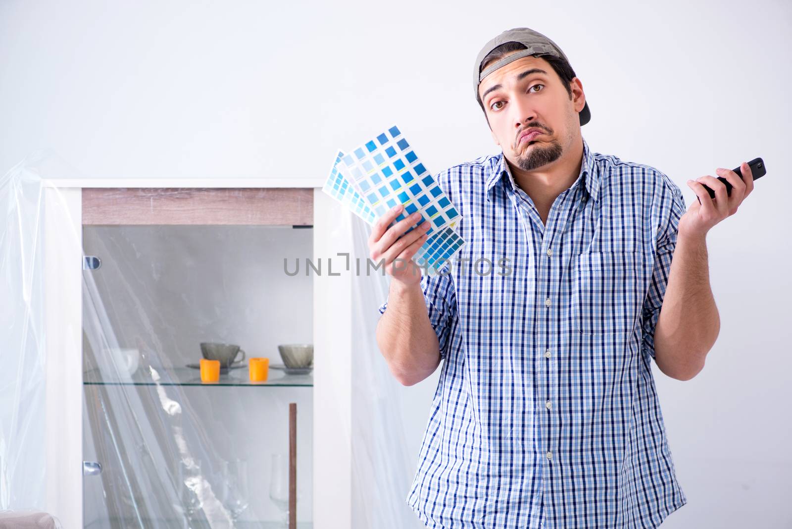 Young man contractor choosing color from rainbow 