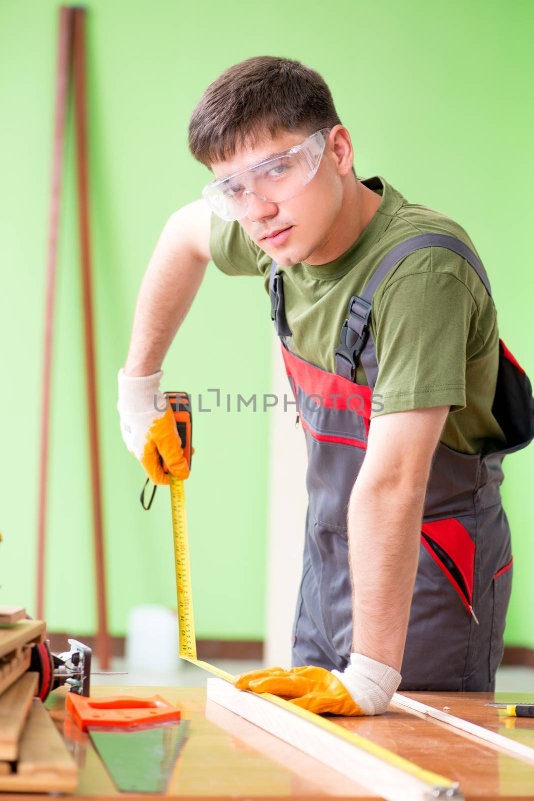 Young man carpenter working in workshop  by Elnur