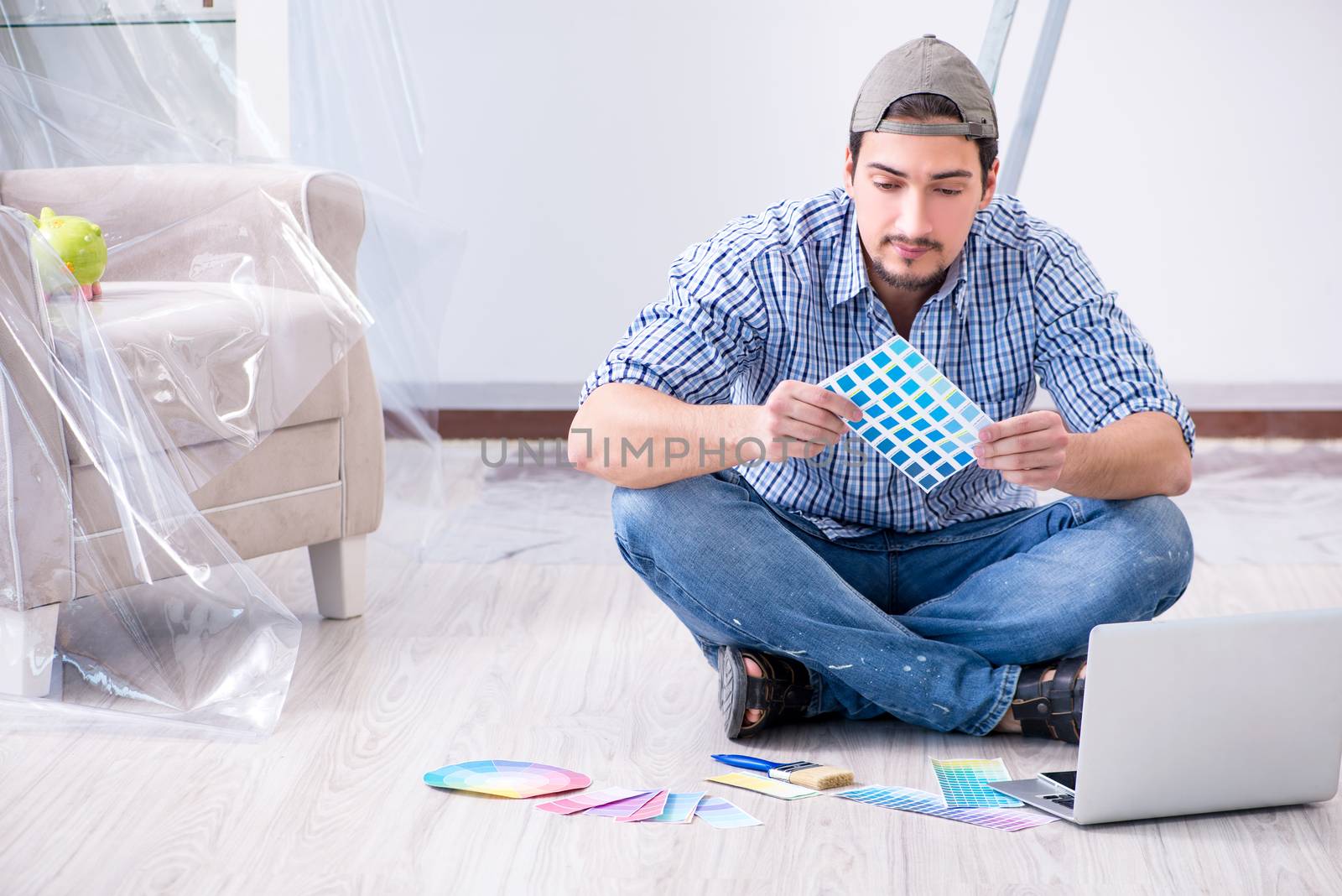 Young man contractor choosing color from rainbow 