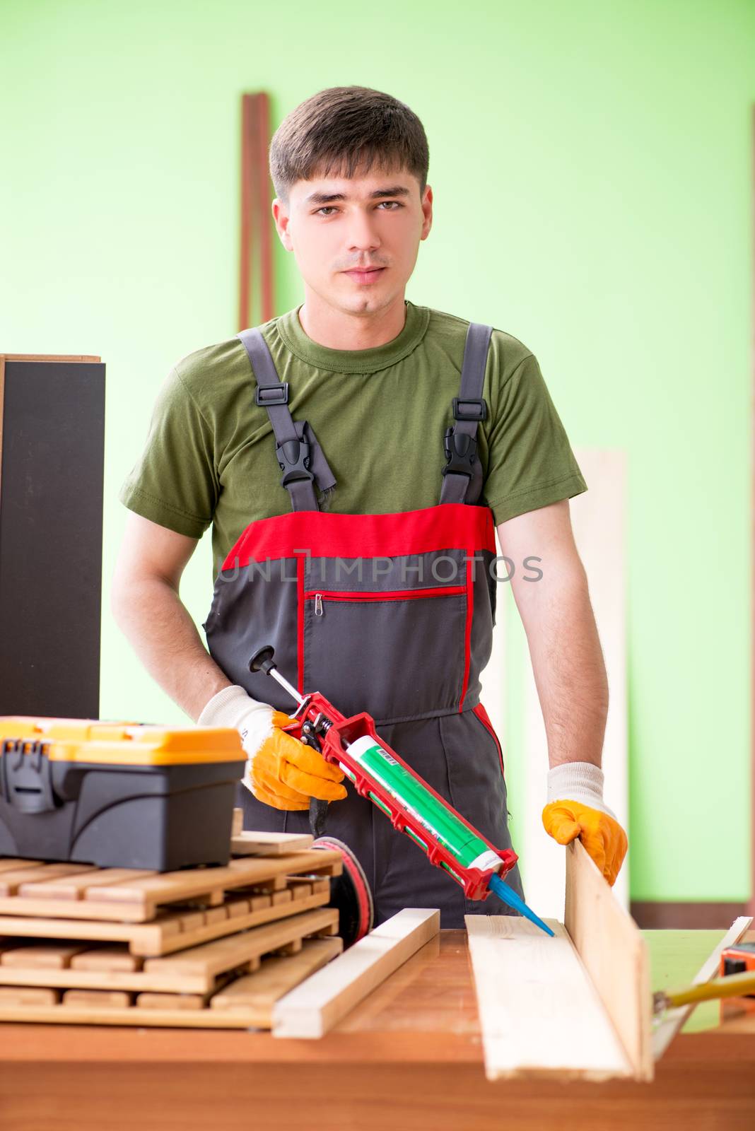 Young man carpenter working in workshop  by Elnur