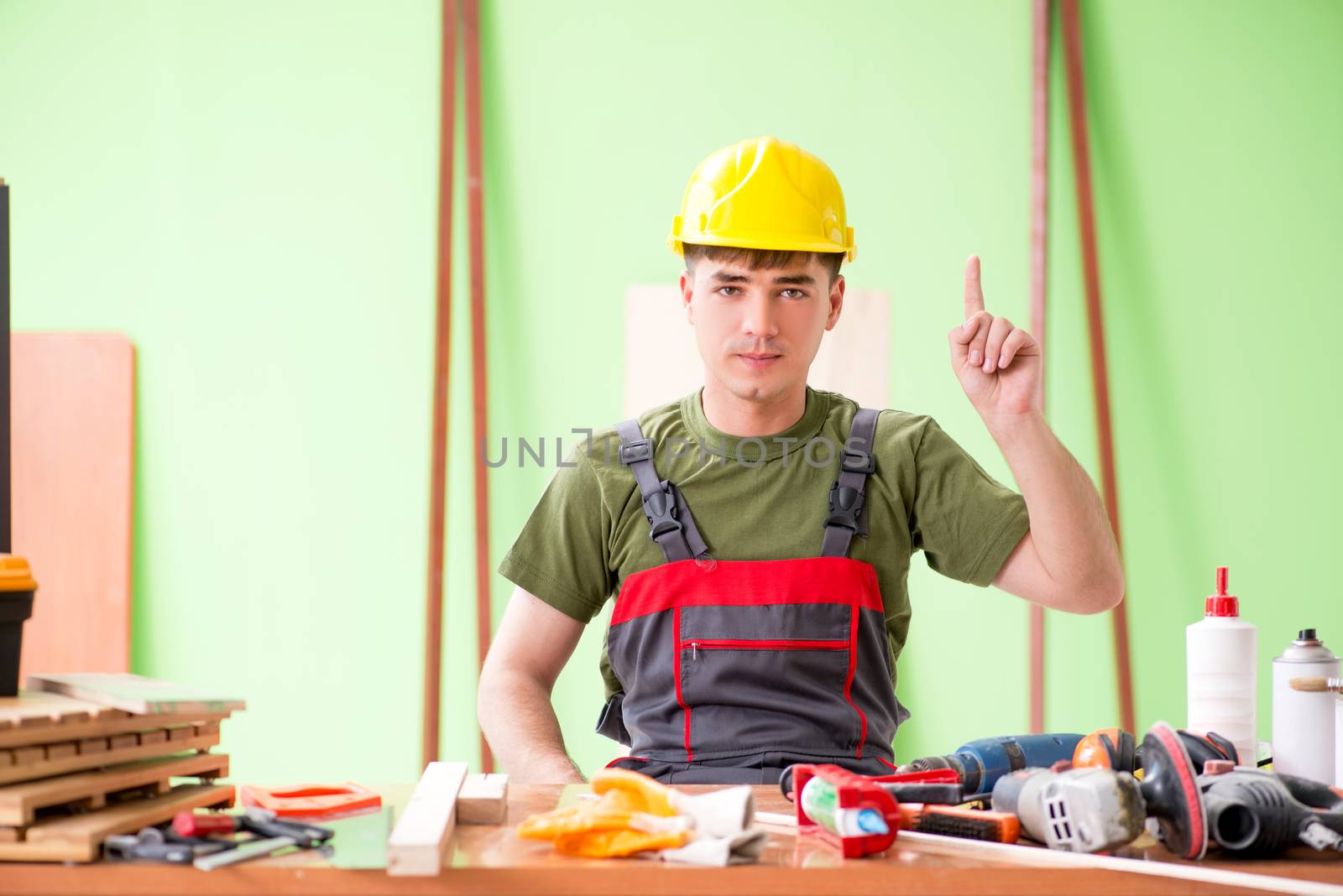 Young man carpenter working in workshop 