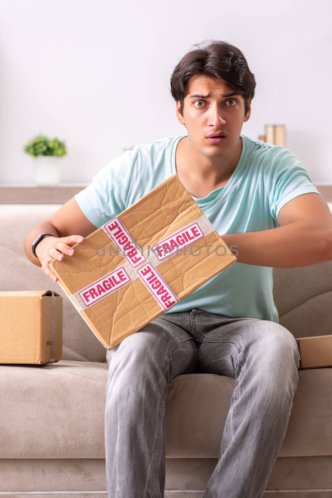 Man opening fragile parcel ordered from internet by Elnur