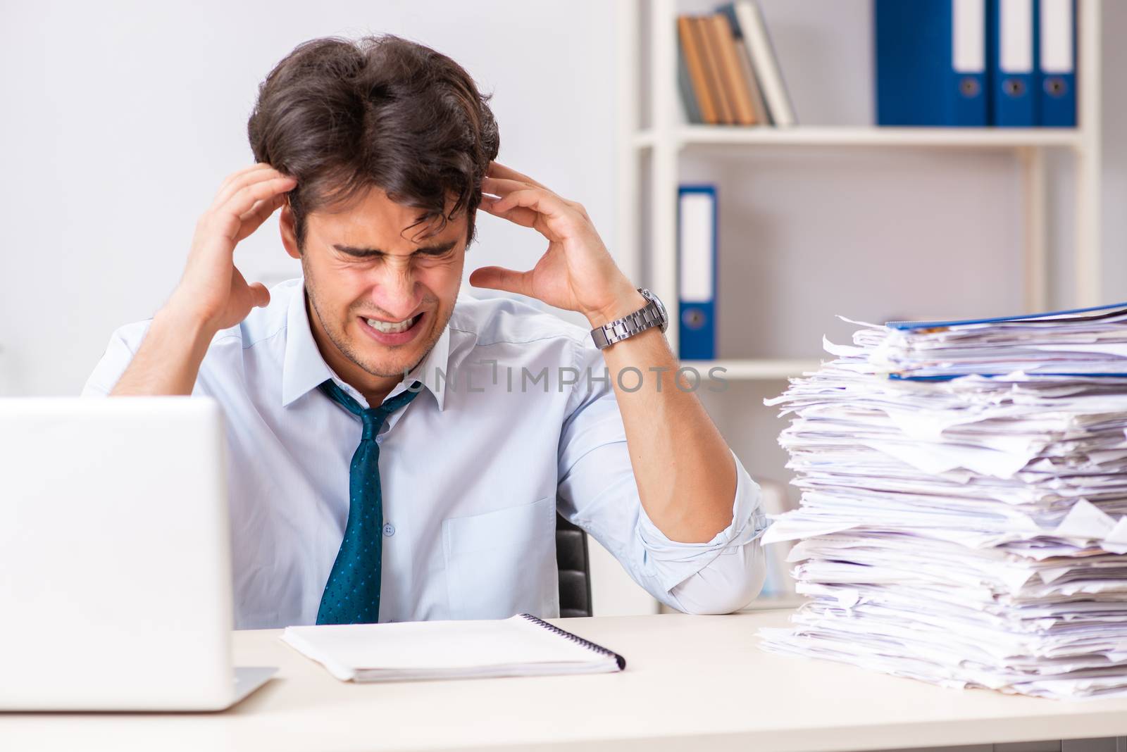 Overloaded busy employee with too much work and paperwork