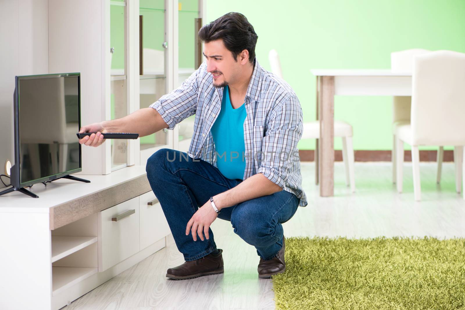 Young man husband repairing tv at home 