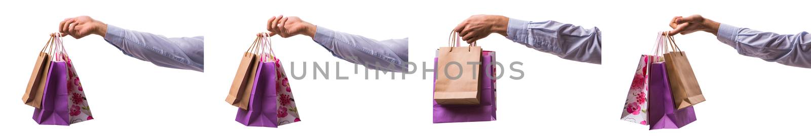 Hand holding shopping bags with christmas shopping on white back by Elnur