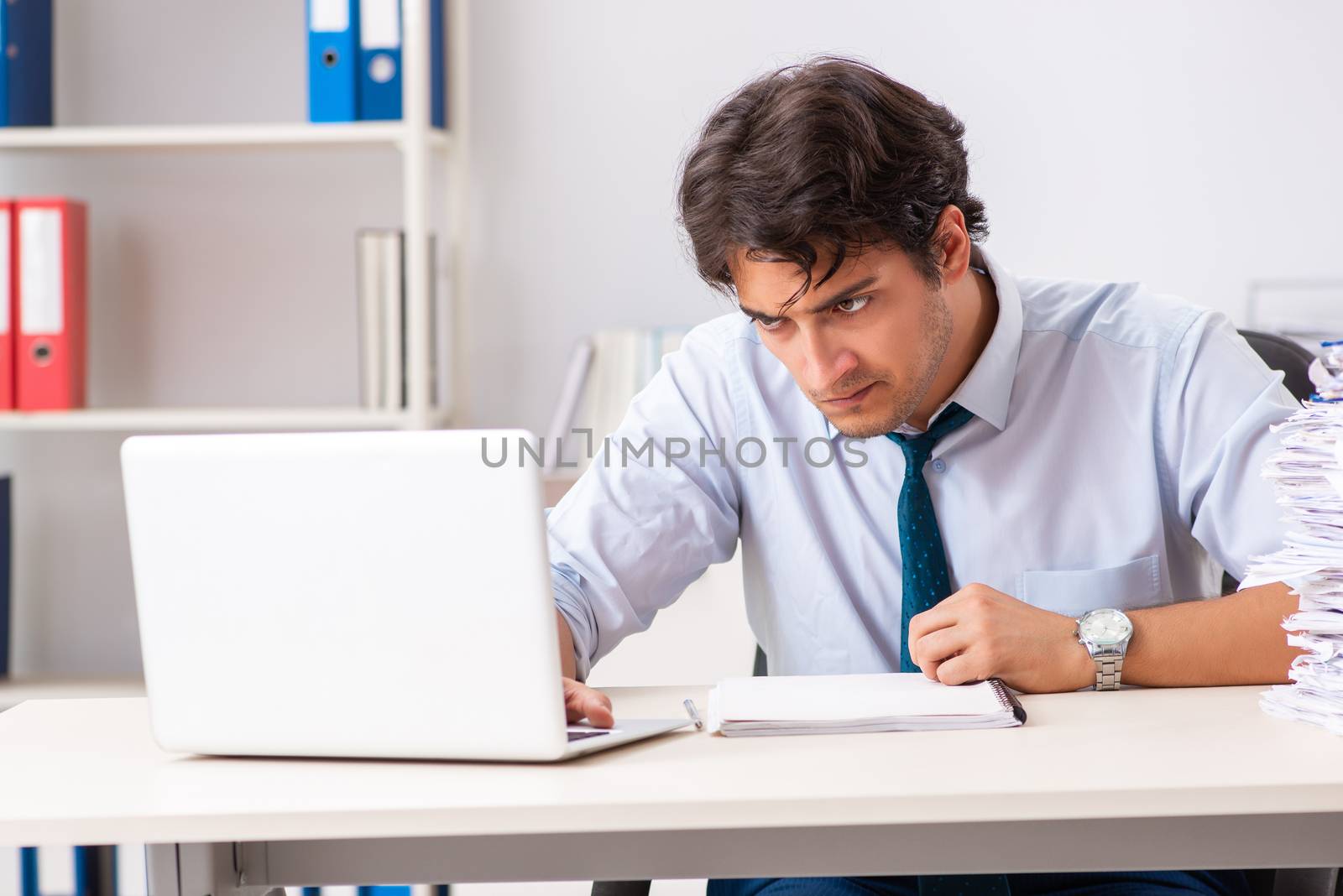 Overloaded busy employee with too much work and paperwork