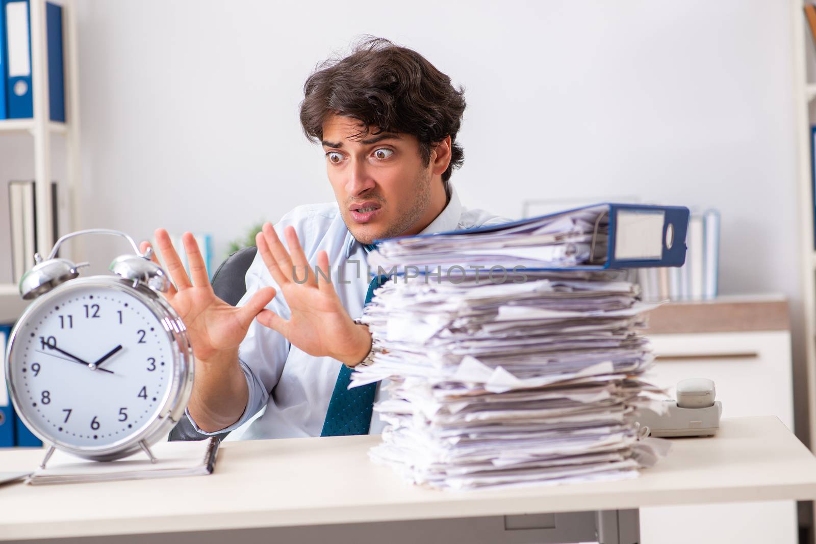 Overloaded busy employee with too much work and paperwork