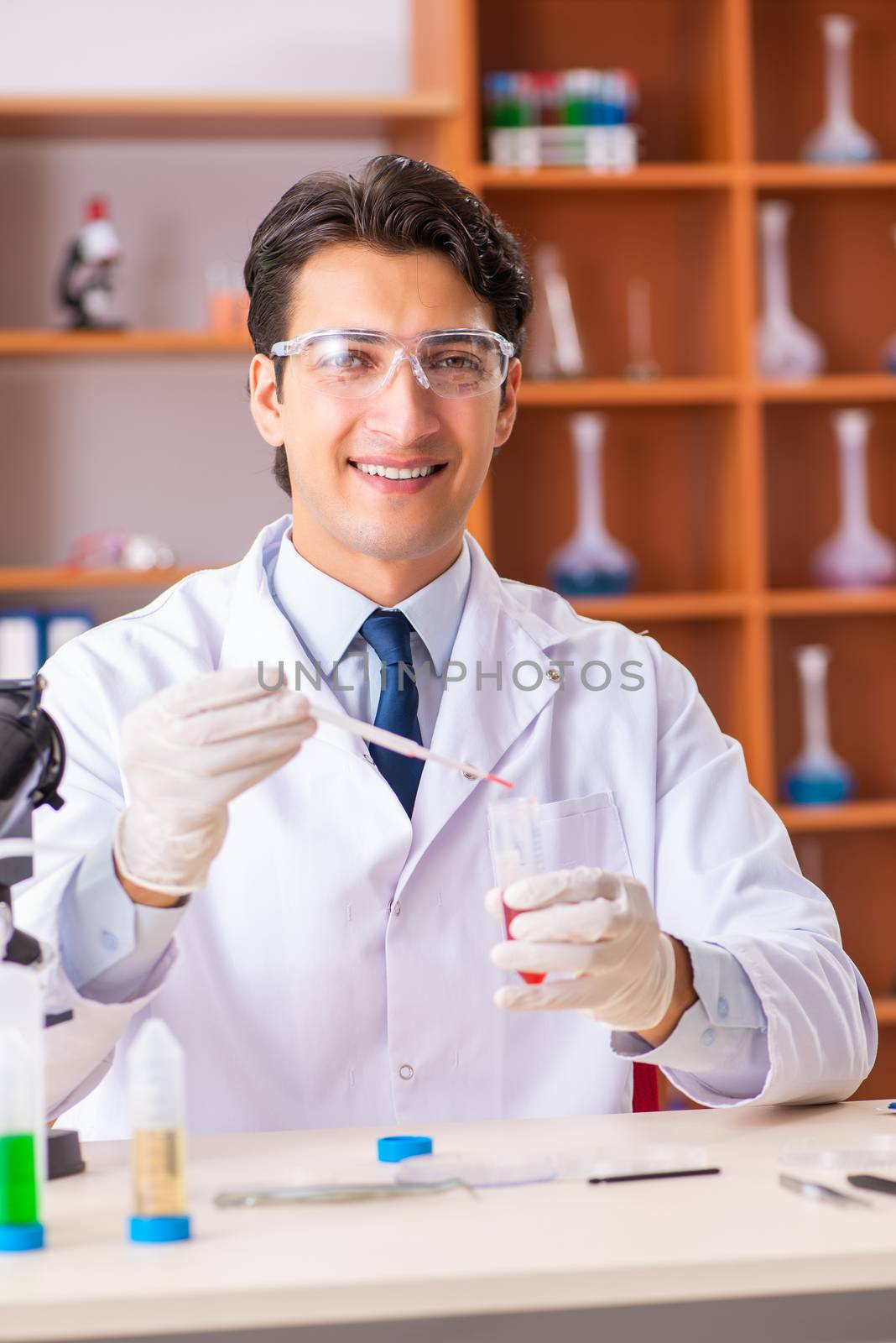 Young handsome biochemist working in the lab   by Elnur