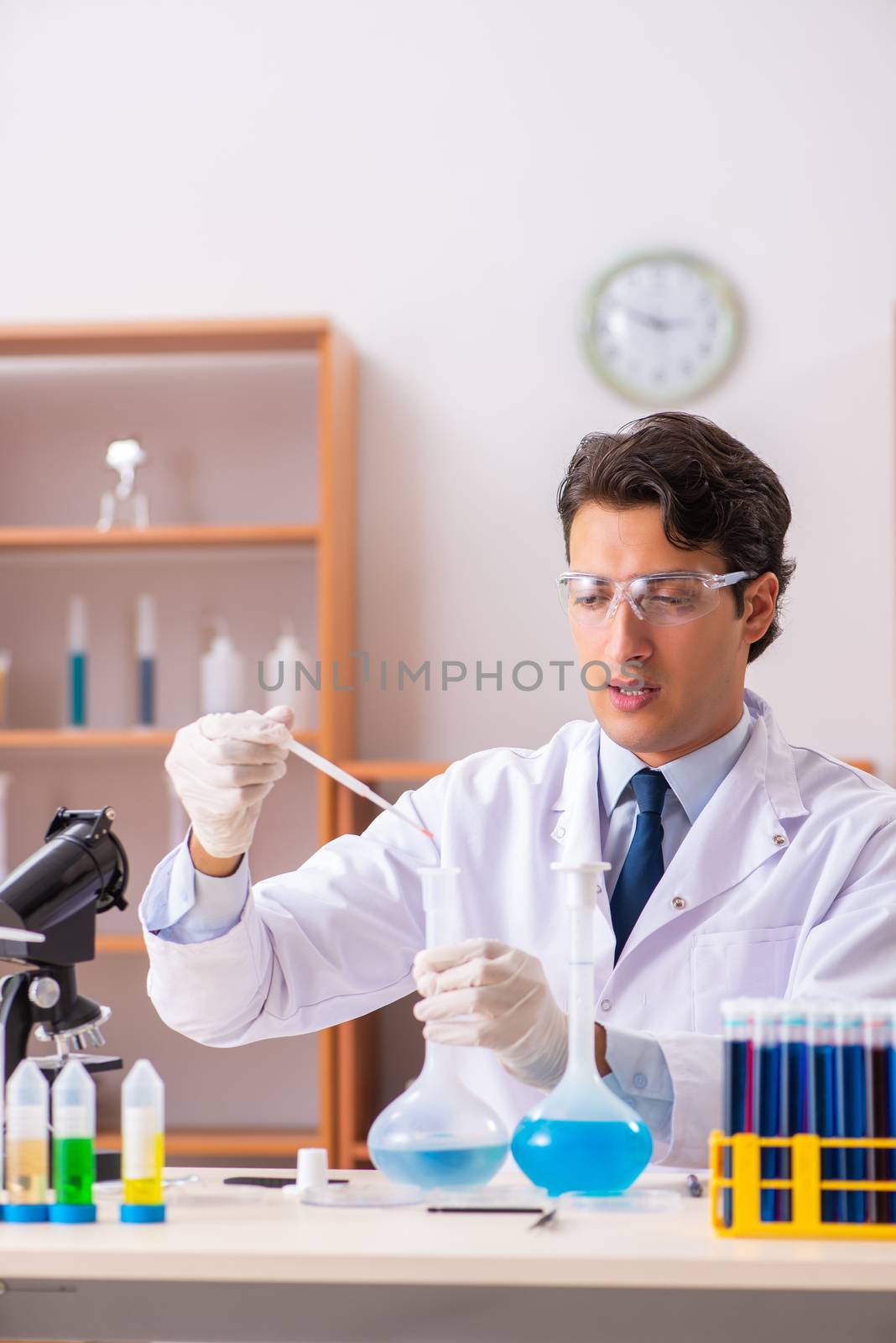 Young handsome biochemist working in the lab 