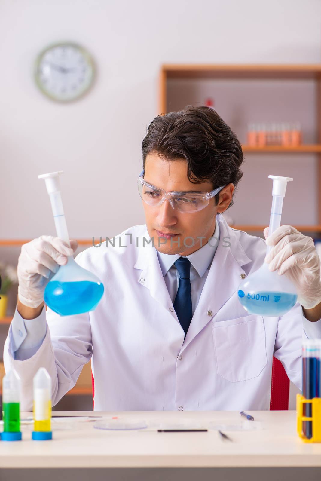 Young handsome biochemist working in the lab 