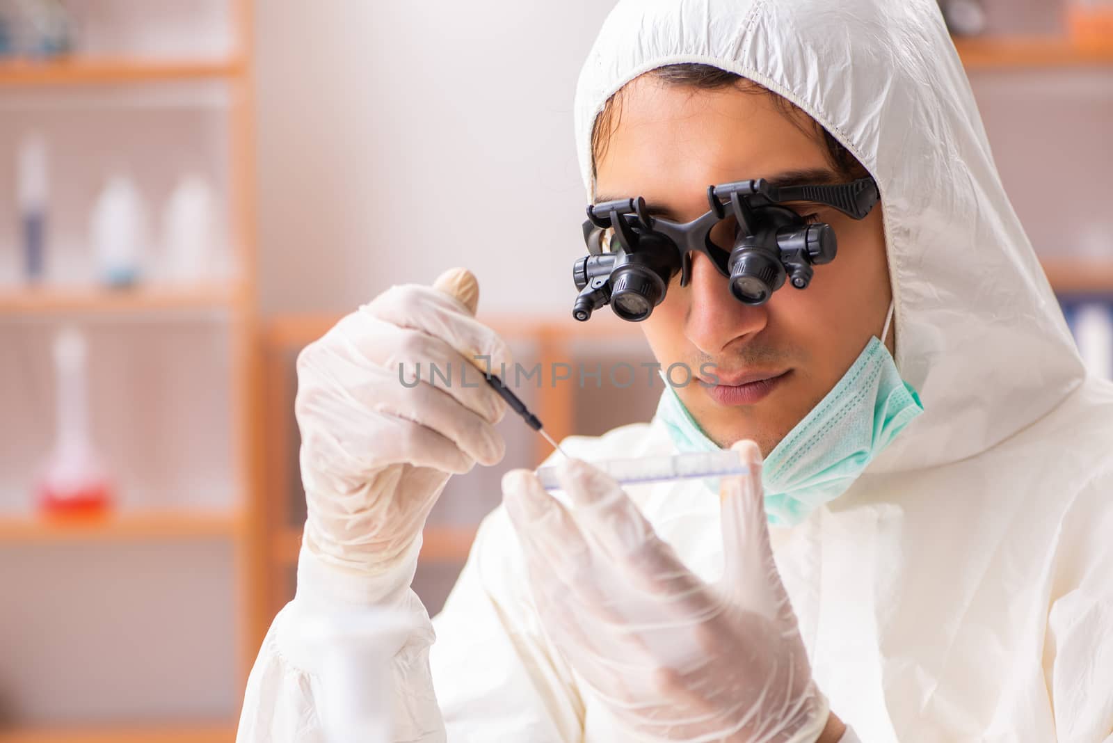 Young biochemist wearing protective suit working in the lab