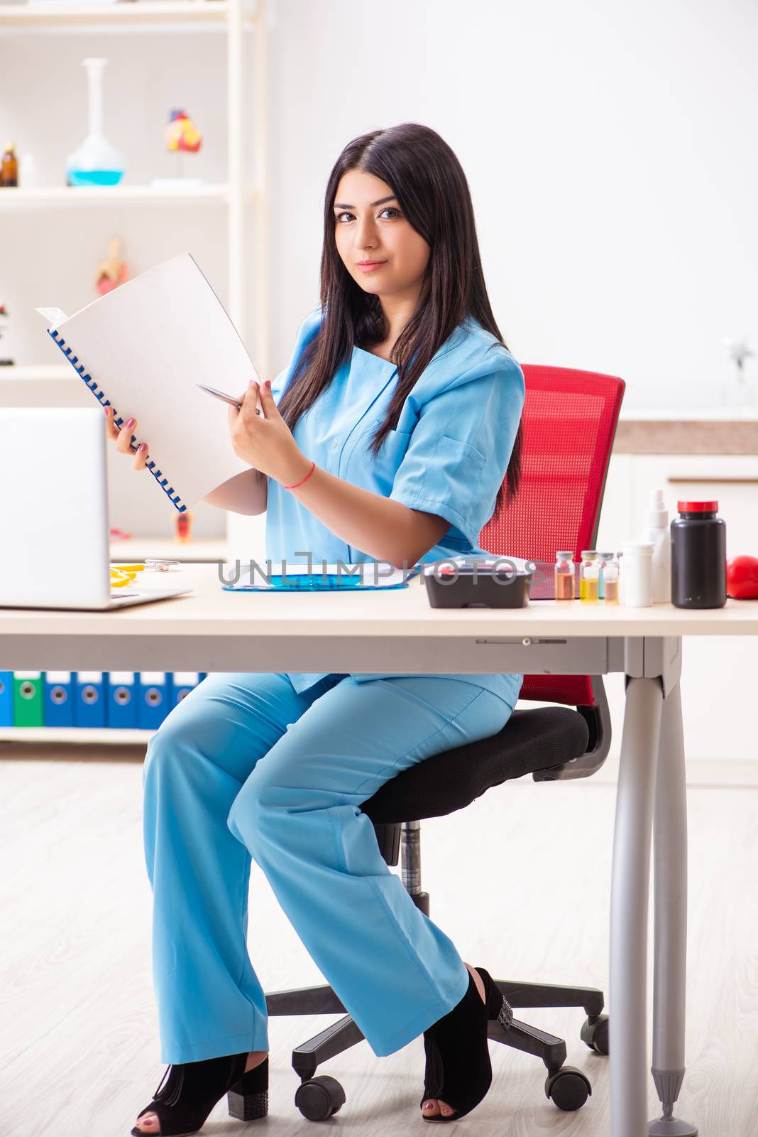 Young beautiful female doctor working in the clinic  by Elnur