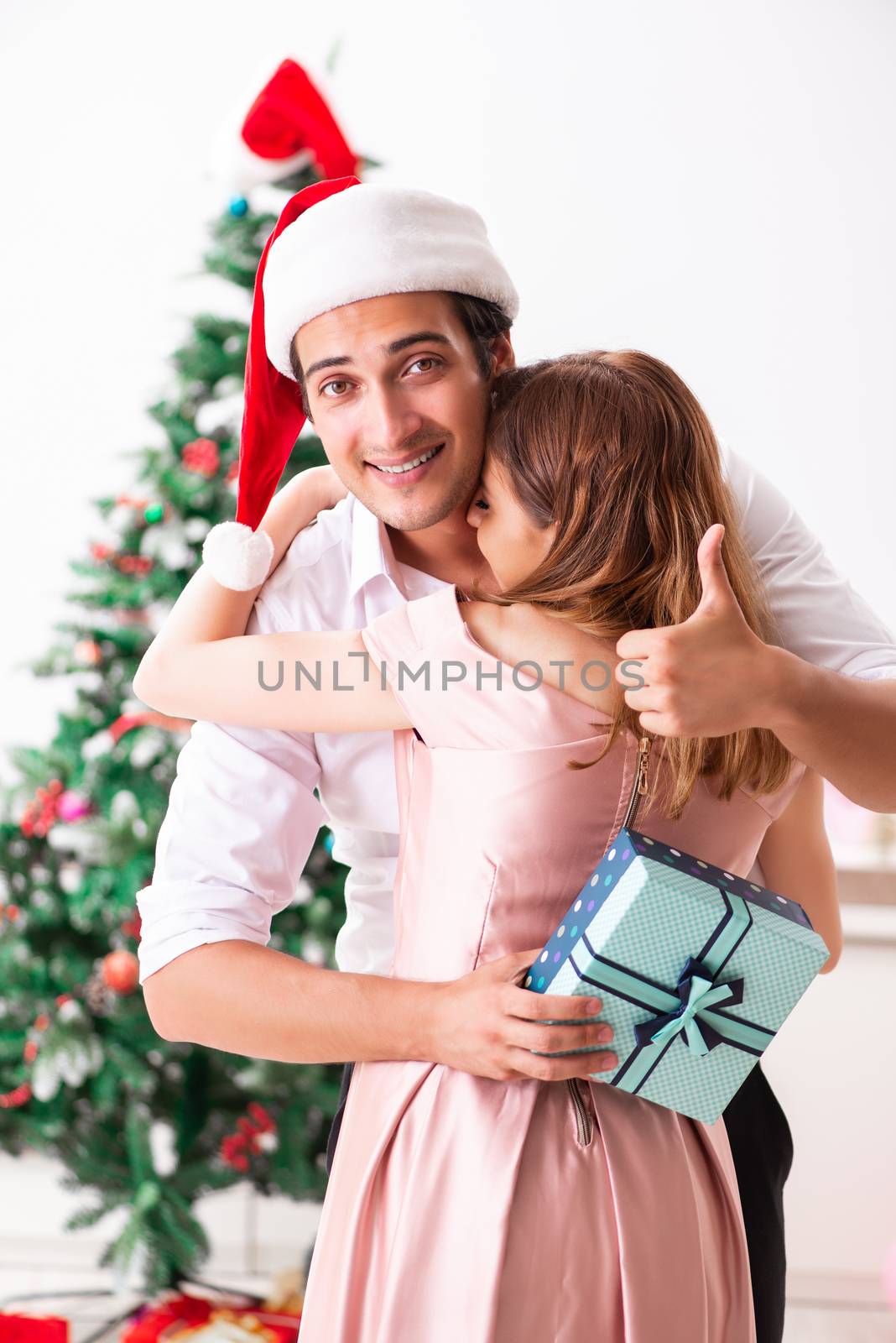 Young couple celebrating christmas at home by Elnur