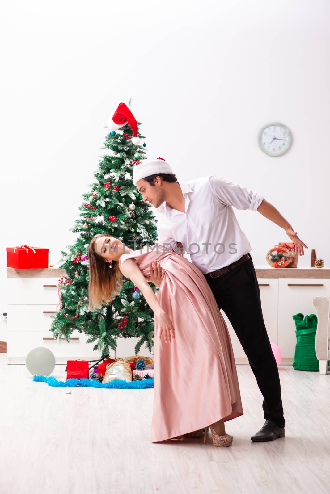 Young pair celebrating christmas at home by Elnur