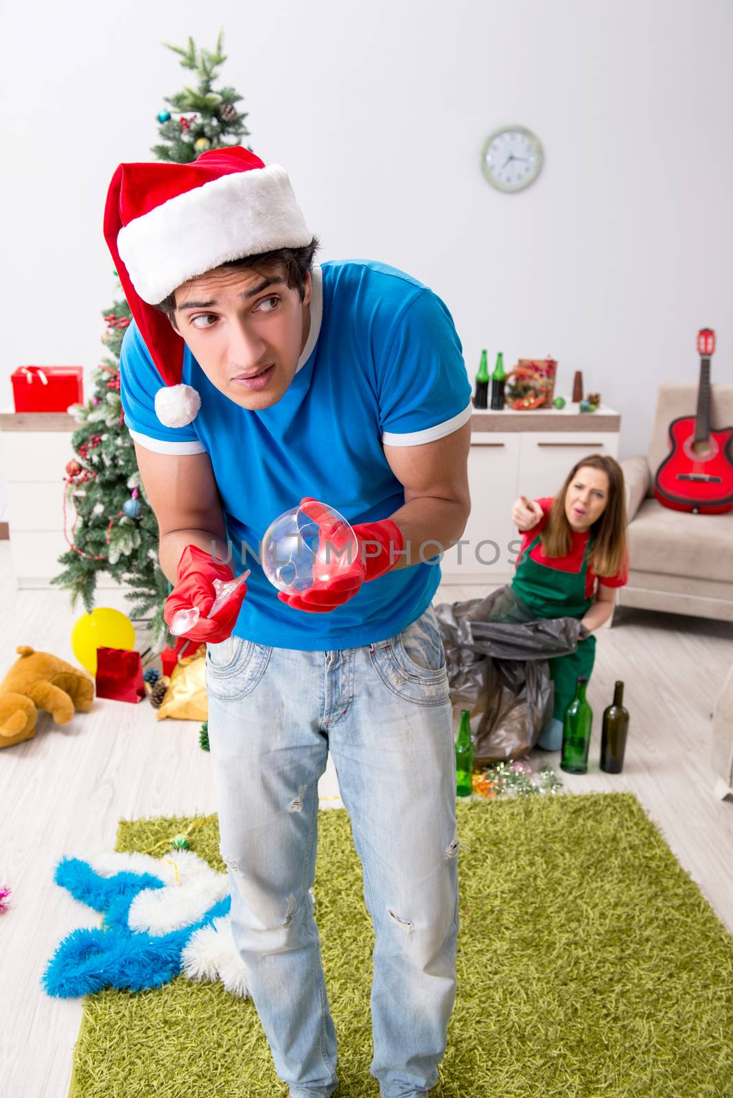 Young family cleaning apartment after christmas party by Elnur