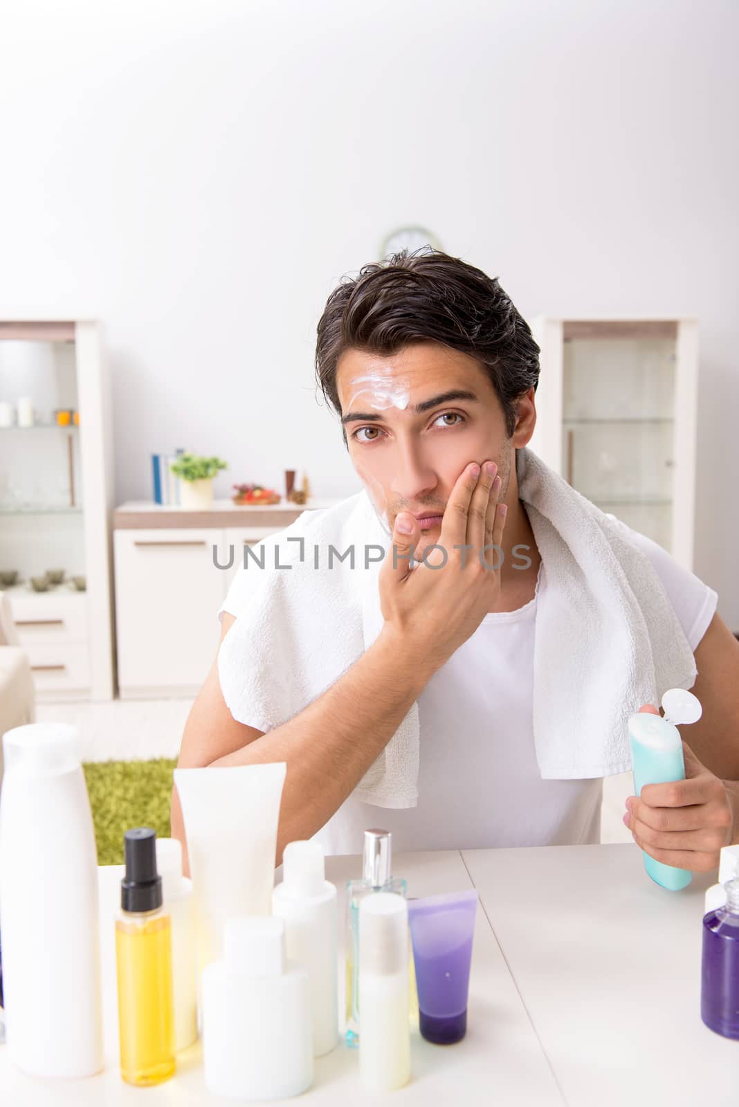 Young handsome man in the bathroom in hygiene concept 